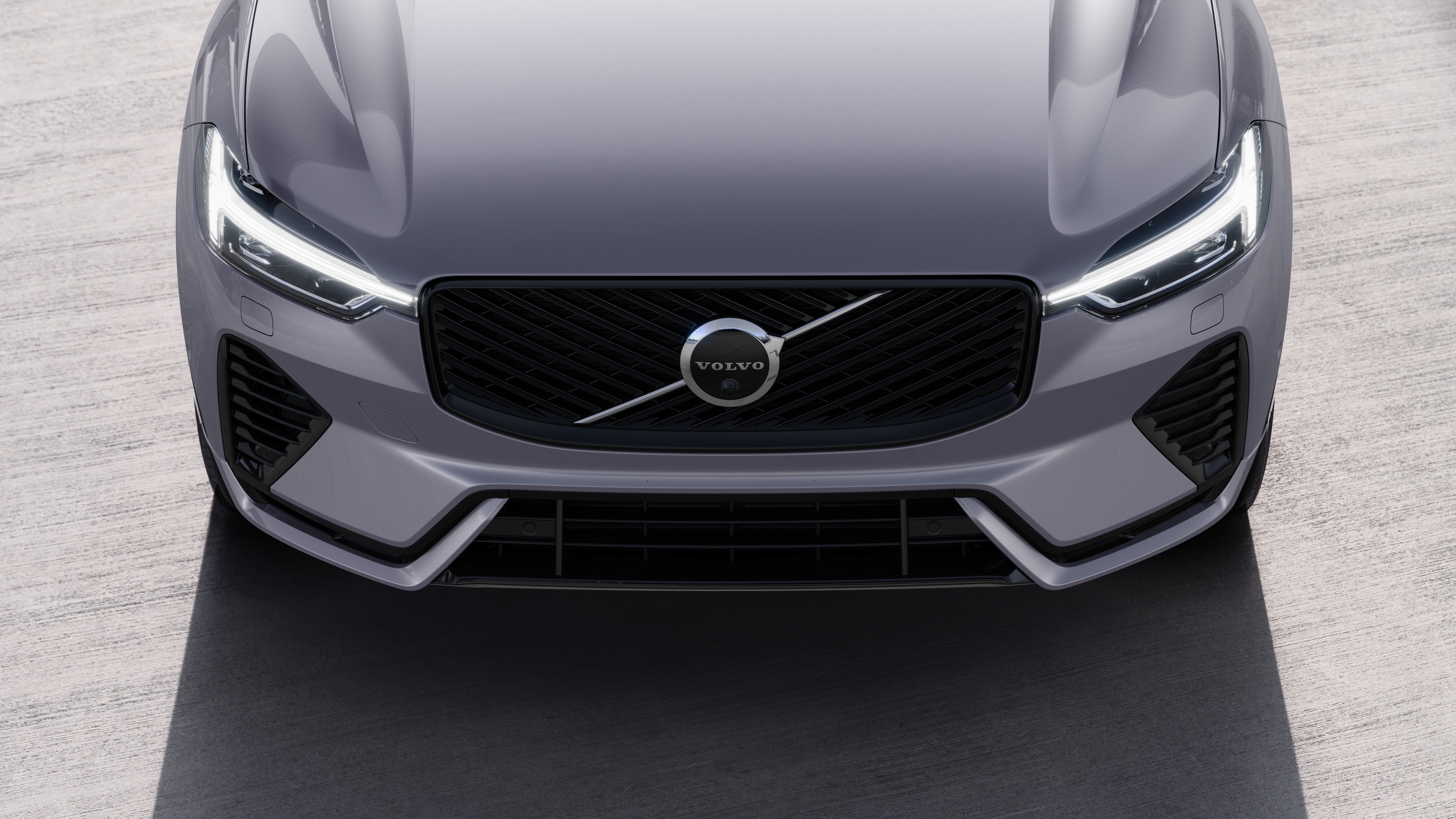 Volvo car exterior in three-quarter view on an urban street background, showing one side, roof, and part of the front.