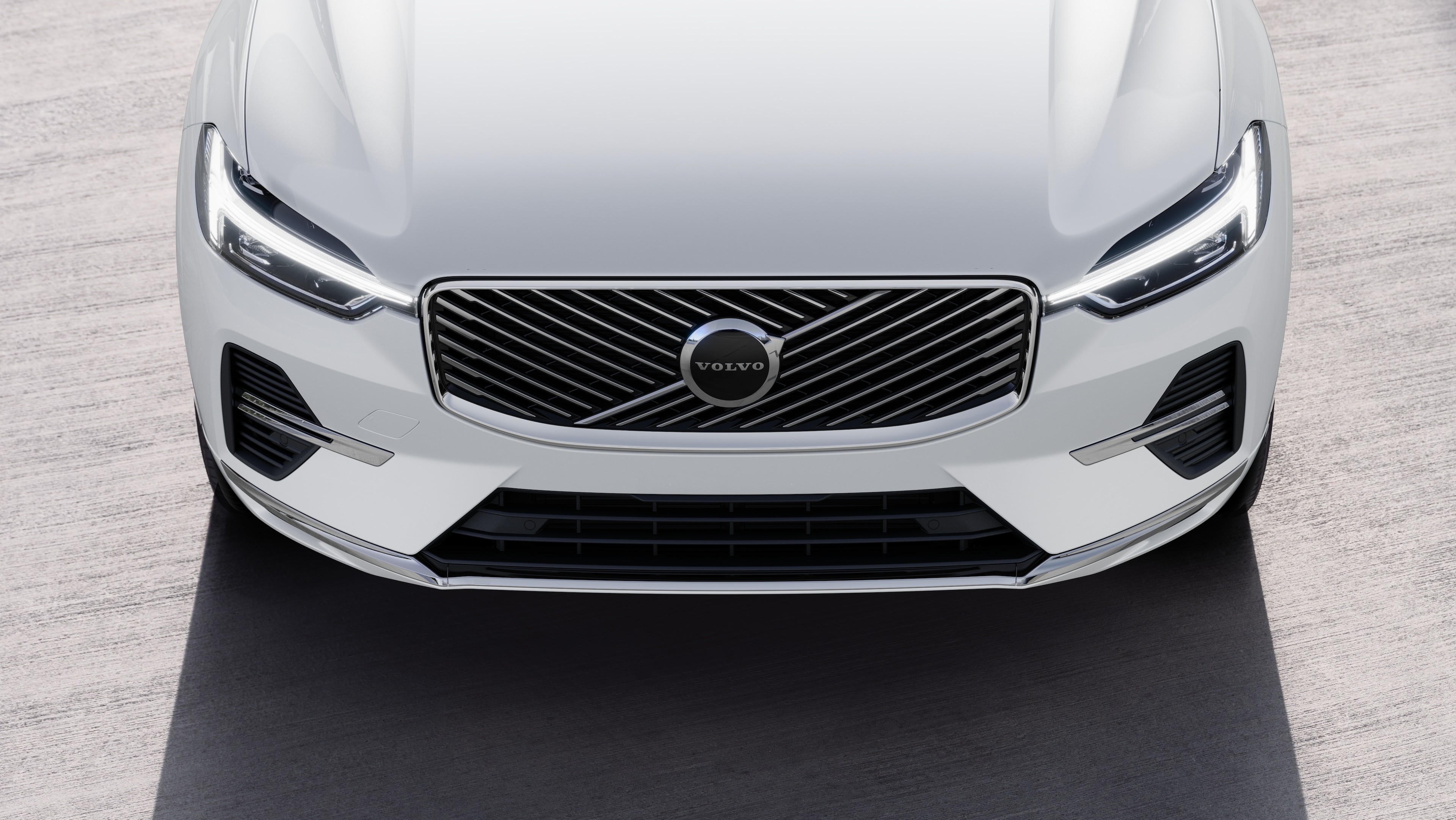 Volvo automašīnas ārpuse trīs ceturtdaļu skatā uz pilsētas ielas fona, parādot vienu pusi, jumtu un daļu priekšpuses.