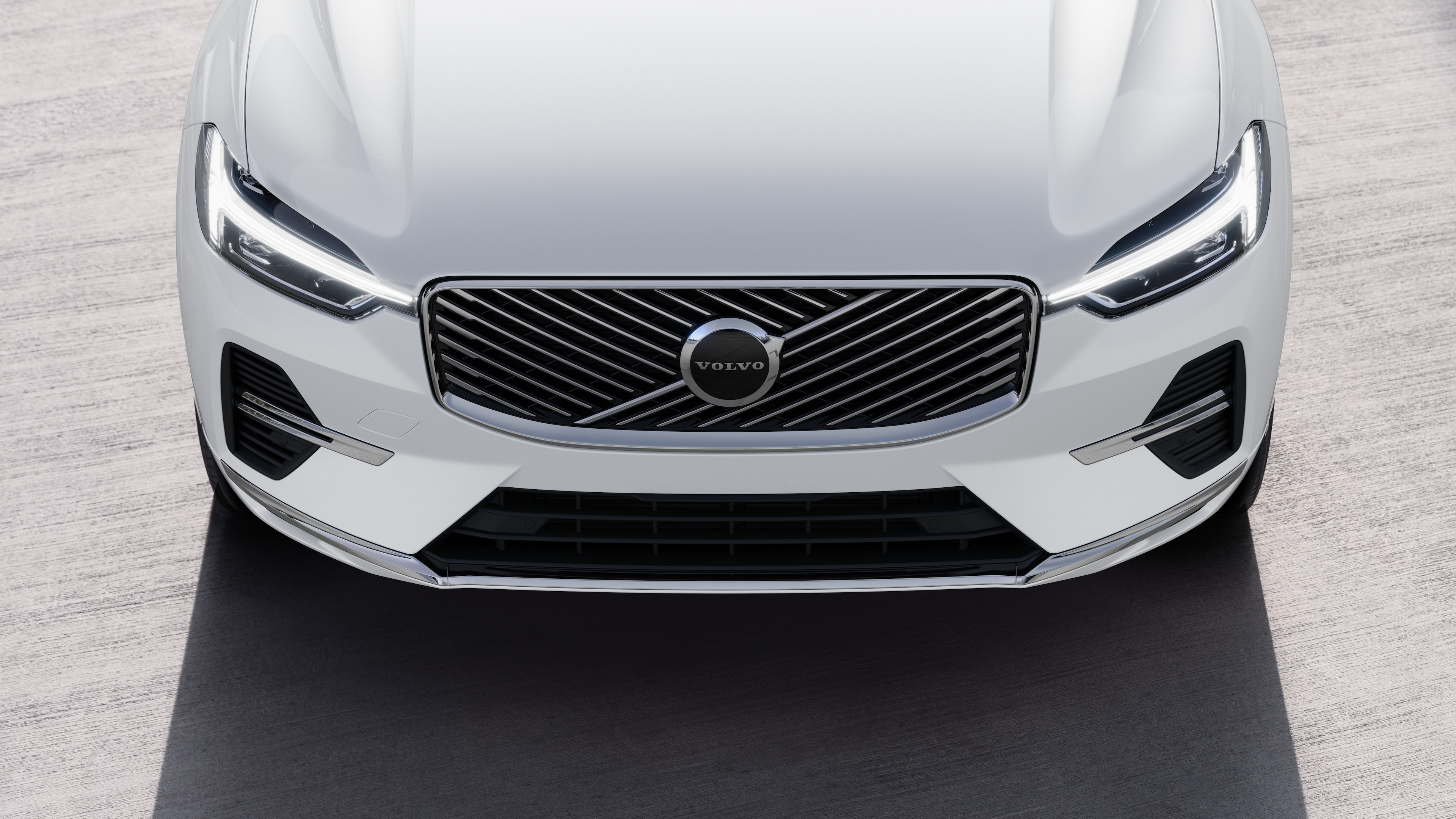 Το εξωτερικό ενός αυτοκινήτου Volvo σε άποψη τριών τετάρτων σε αστικό φόντο, όπου φαίνεται η μία πλευρά, η οροφή και μέρος του εμπρός.