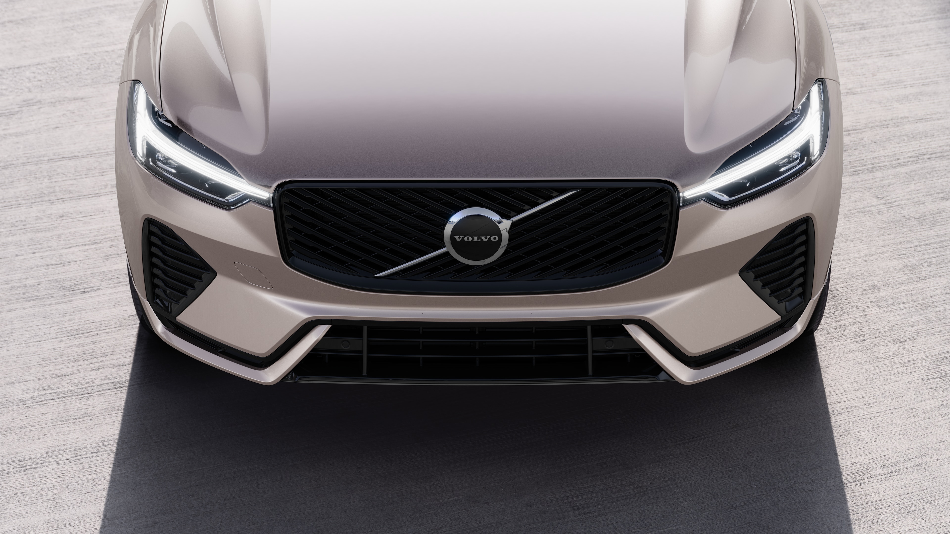 Volvo automašīnas ārpuse trīs ceturtdaļu skatā uz pilsētas ielas fona, parādot vienu pusi, jumtu un daļu priekšpuses.