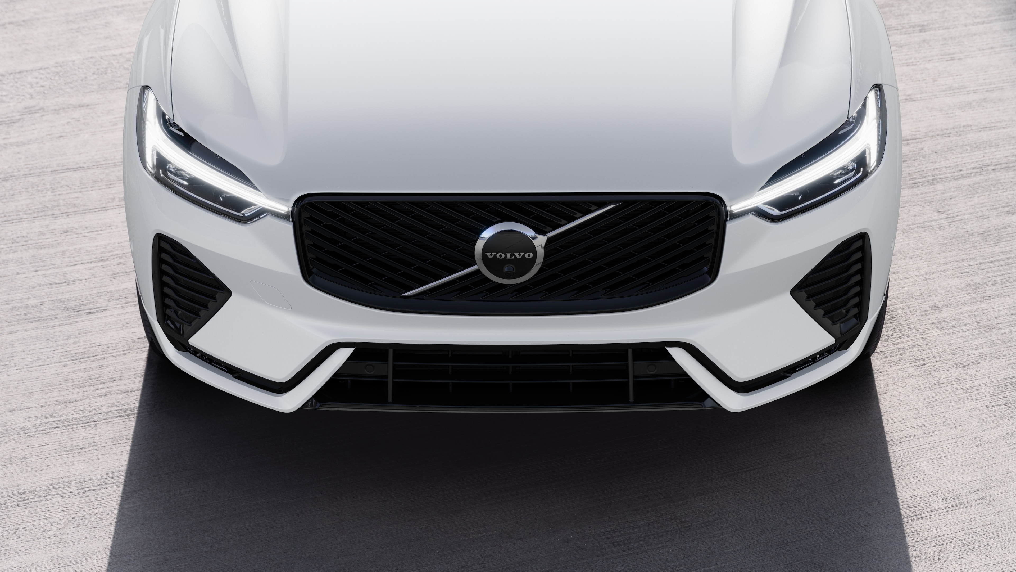 Volvo car exterior in three-quarter view on an urban street background, showing one side, roof, and part of the front.