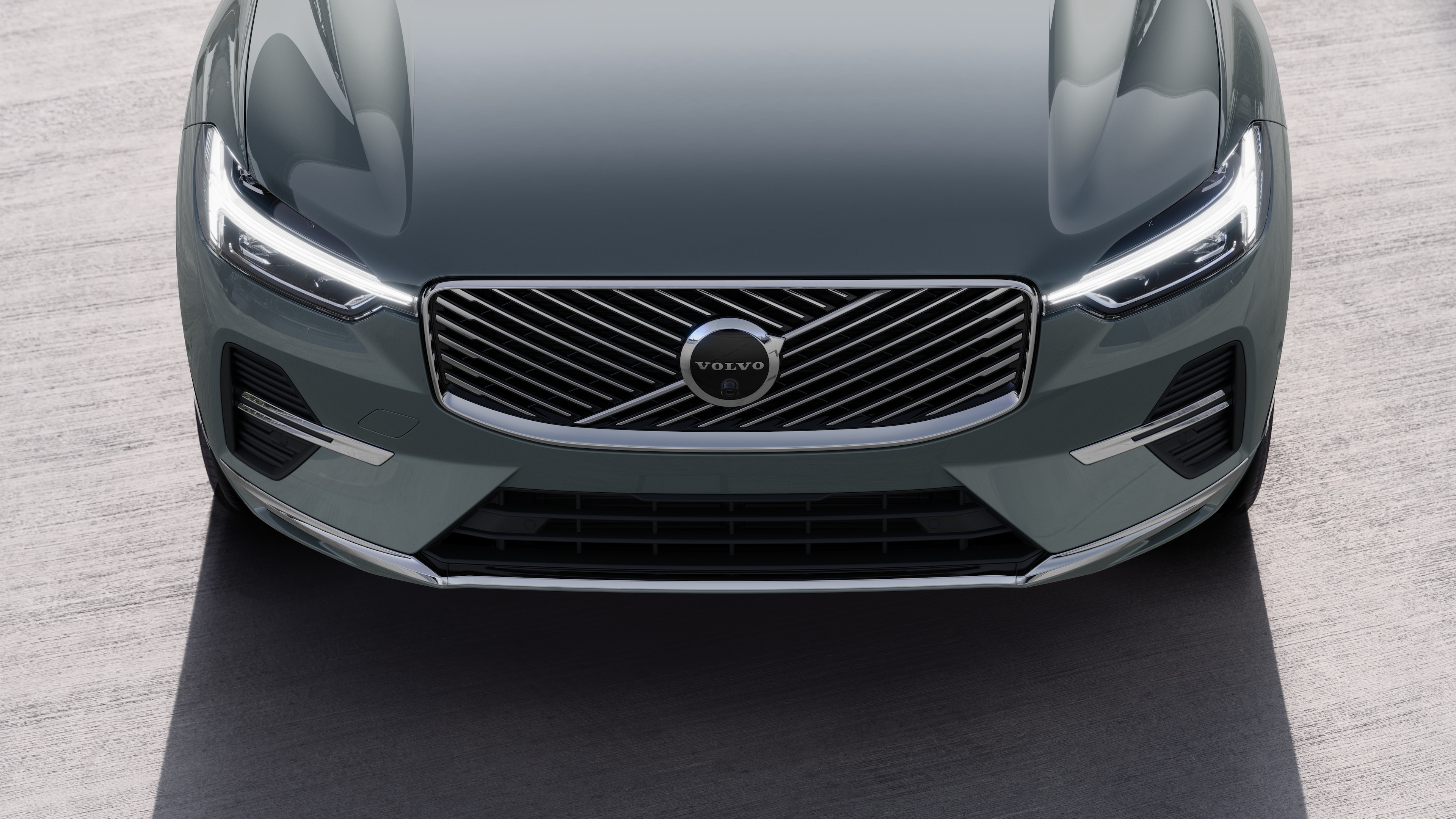 Volvo car exterior in three-quarter view on an urban street background, showing one side, roof, and part of the front.