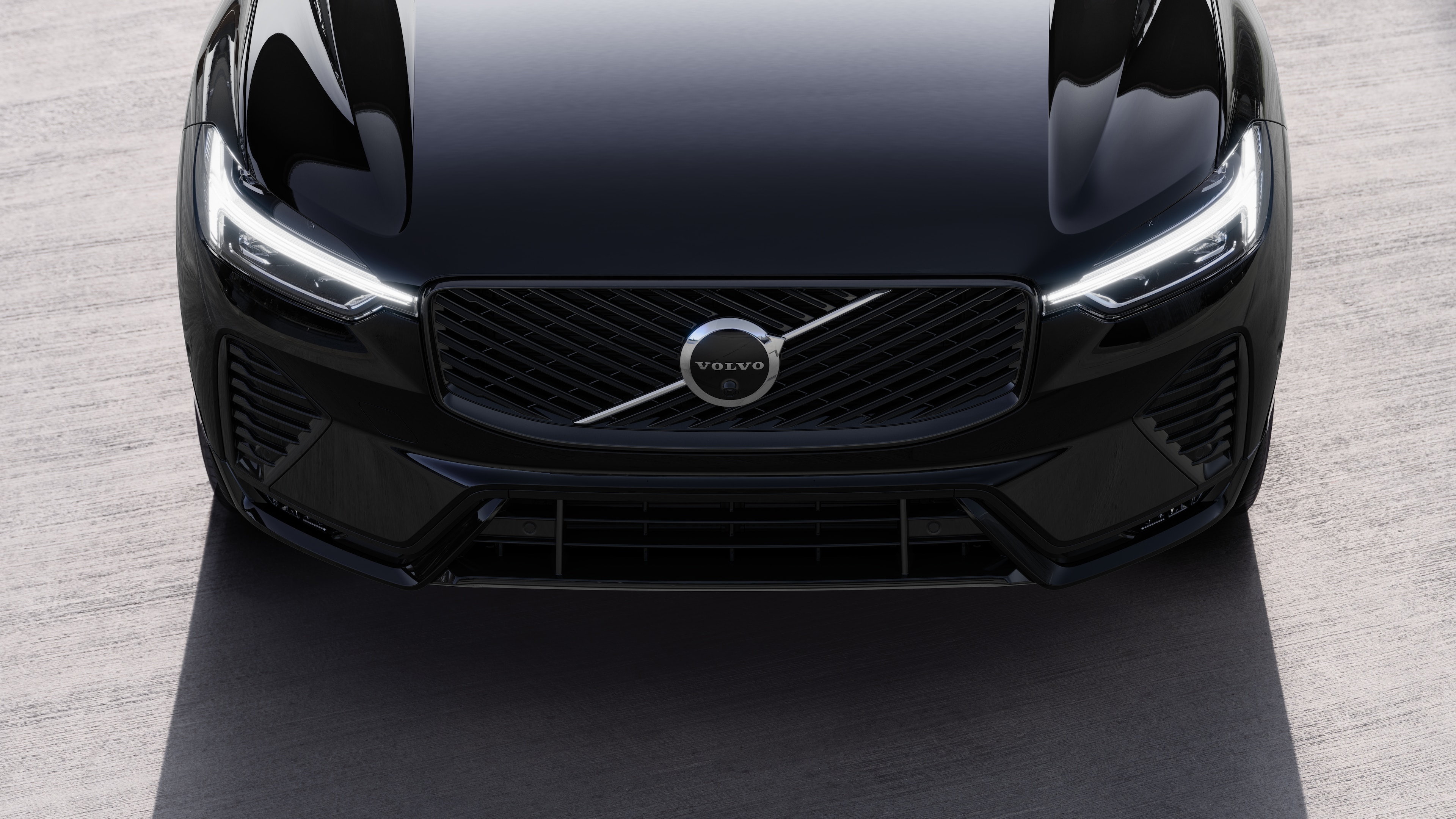 Volvo car exterior in three-quarter view on an urban street background, showing one side, roof, and part of the front.