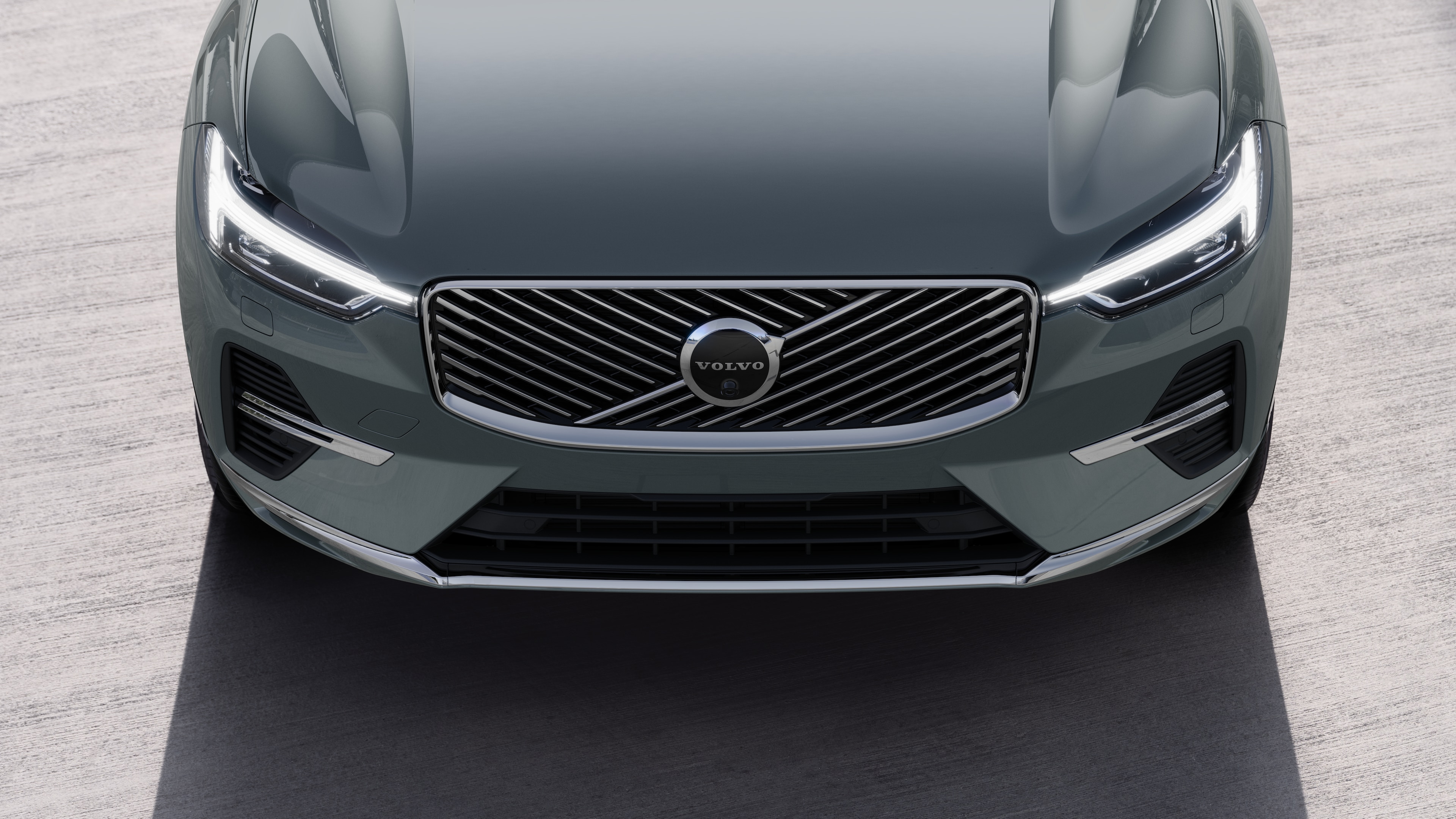 Volvo car exterior in three-quarter view on an urban street background, showing one side, roof, and part of the front.