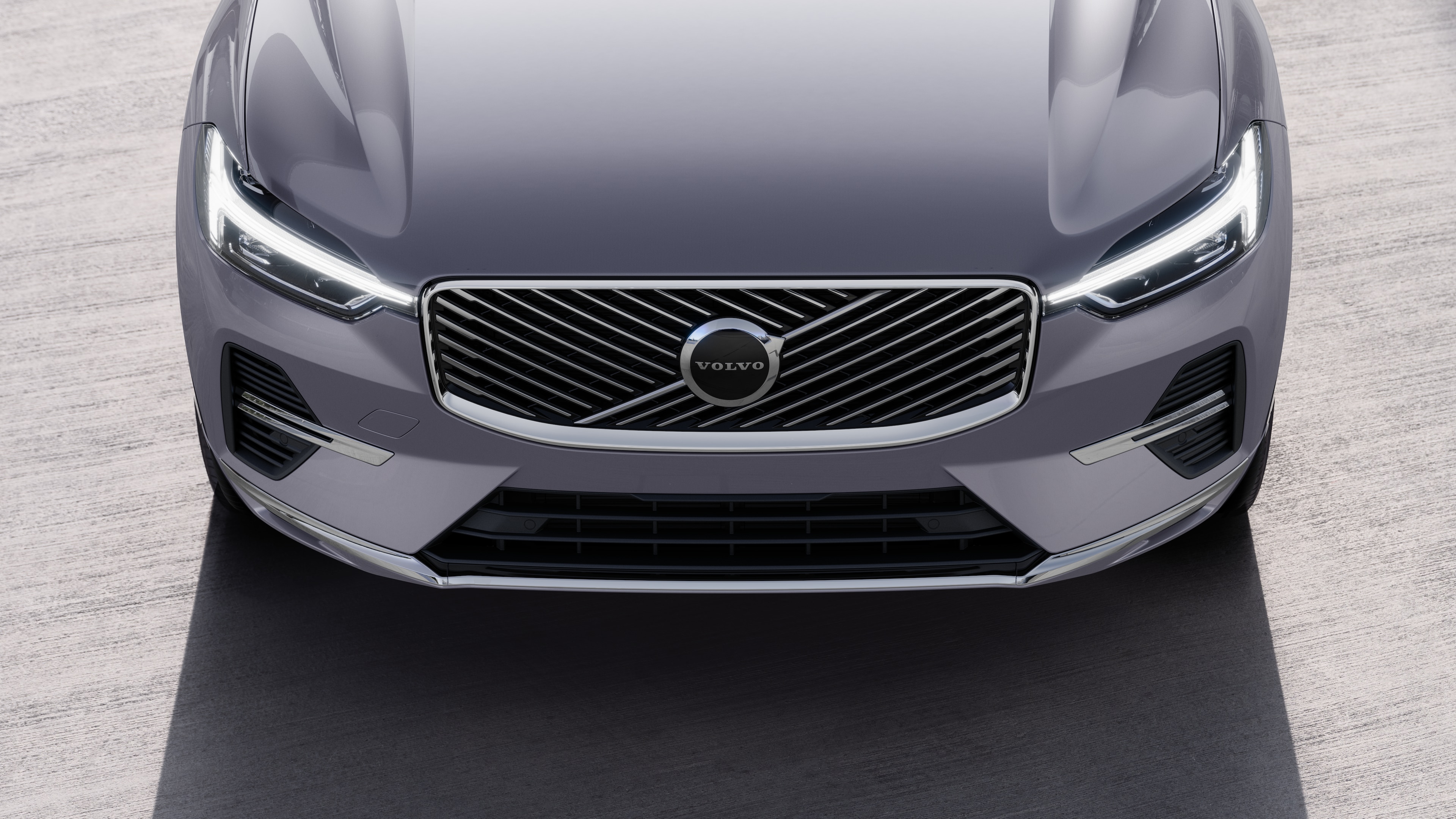 Volvo automašīnas ārpuse trīs ceturtdaļu skatā uz pilsētas ielas fona, parādot vienu pusi, jumtu un daļu priekšpuses.