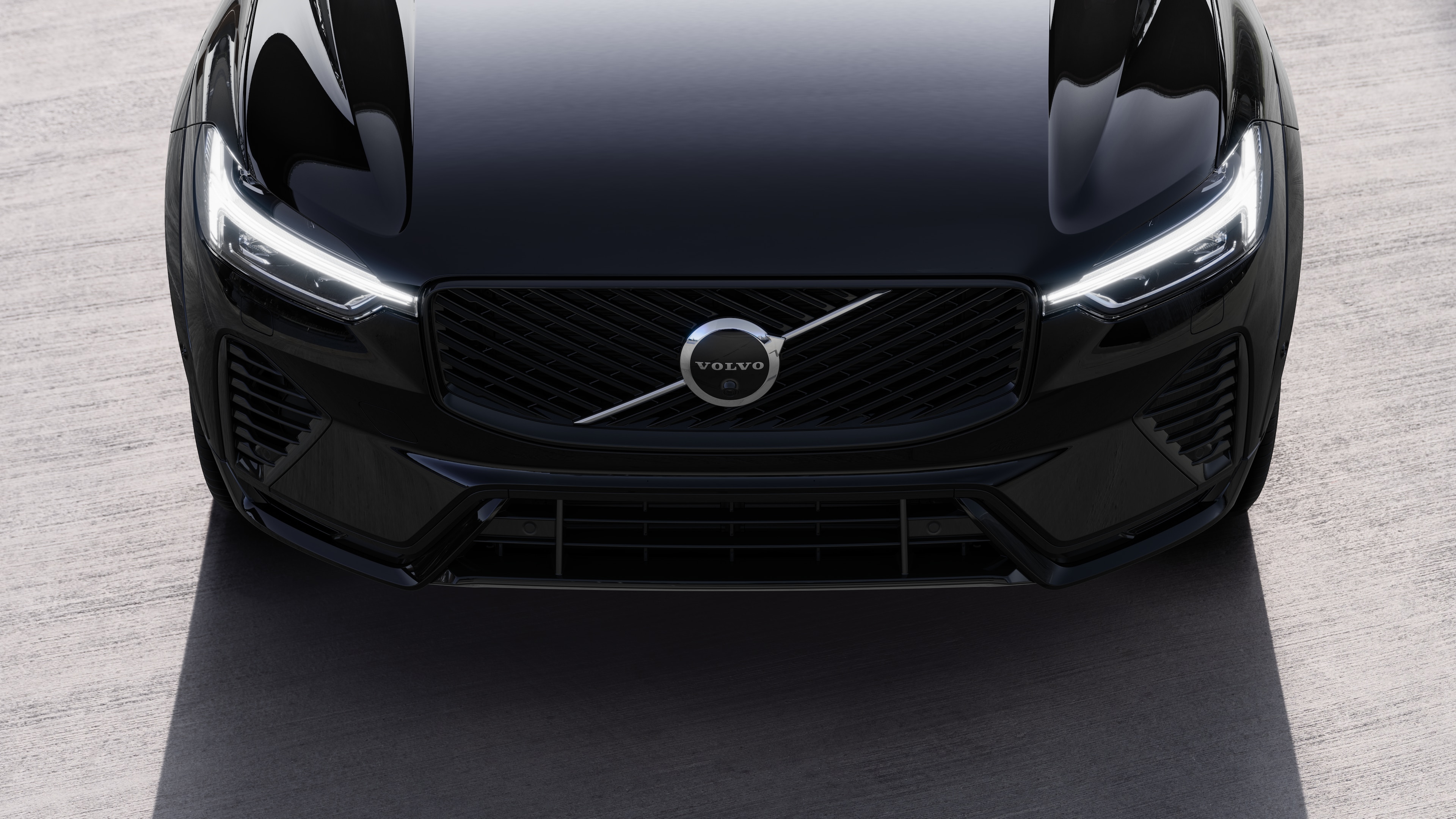 Volvobilens exteriör i trekvartsvy mot en urban gatubakgrund, som visar ena sidan, taket och en del av fronten.