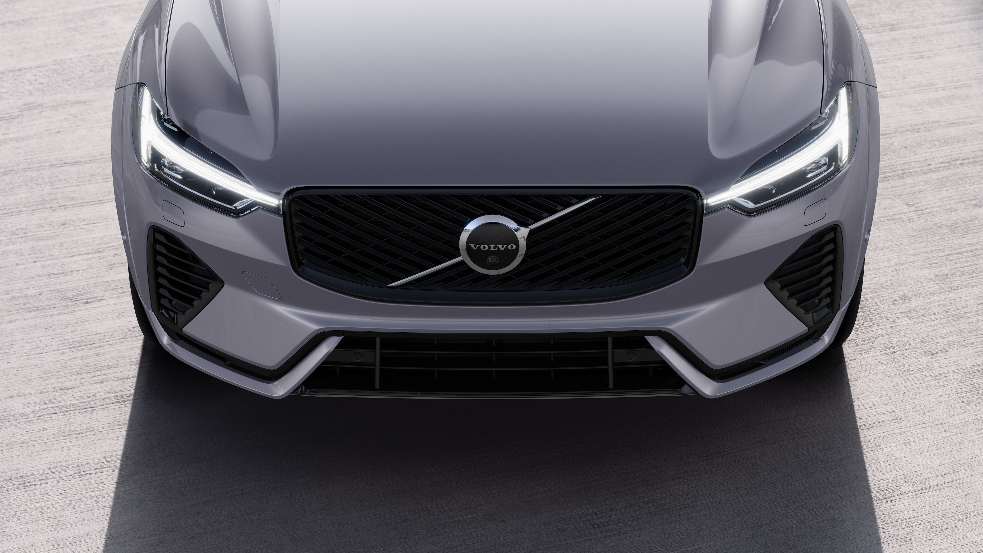 Exterior del vehículo Volvo en vista de tres cuartos sobre un fondo urbano de calles, mostrando un lado, el techo y parte del frente.