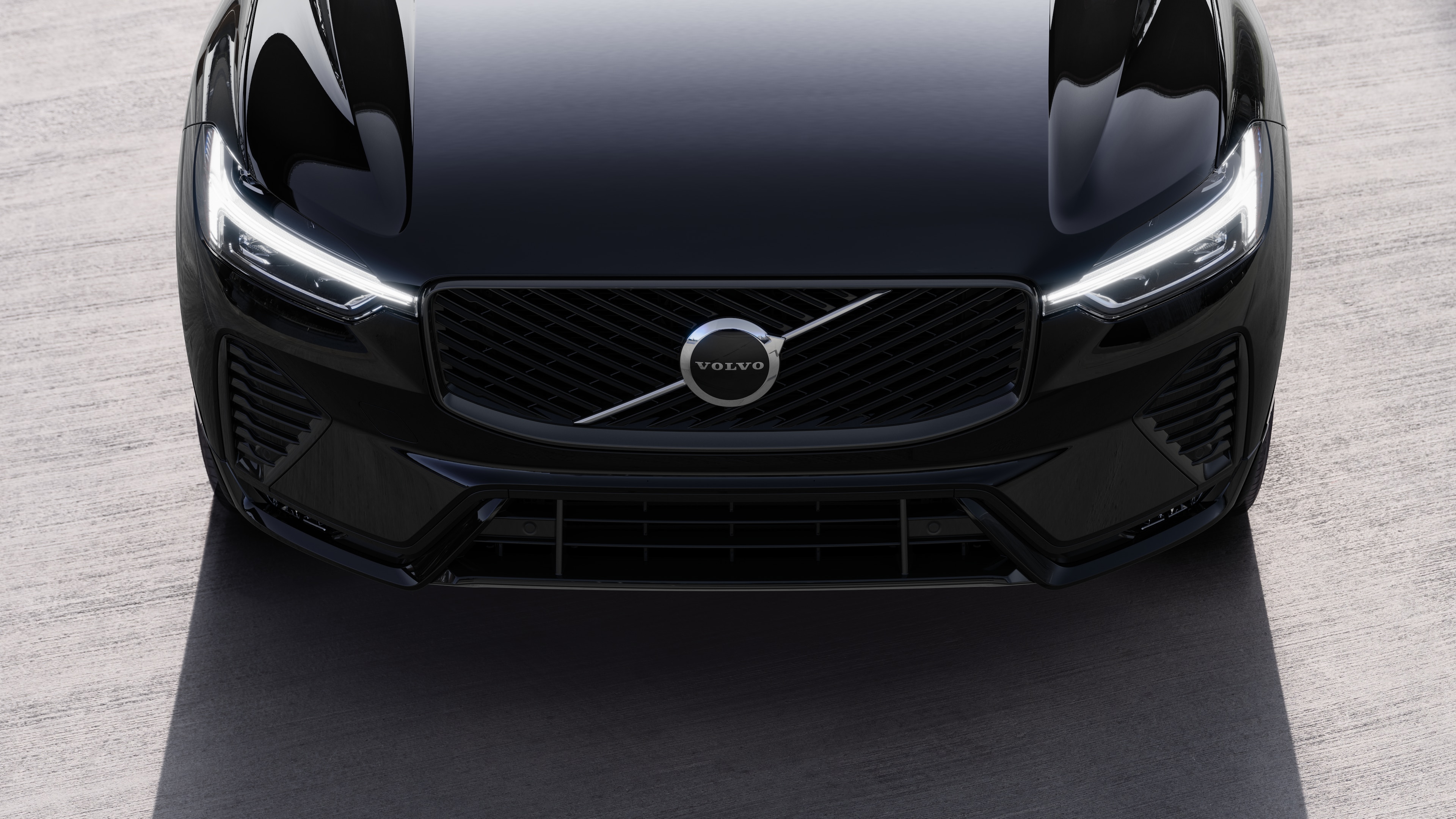 Volvo car exterior in three-quarter view on an urban street background, showing one side, roof, and part of the front.