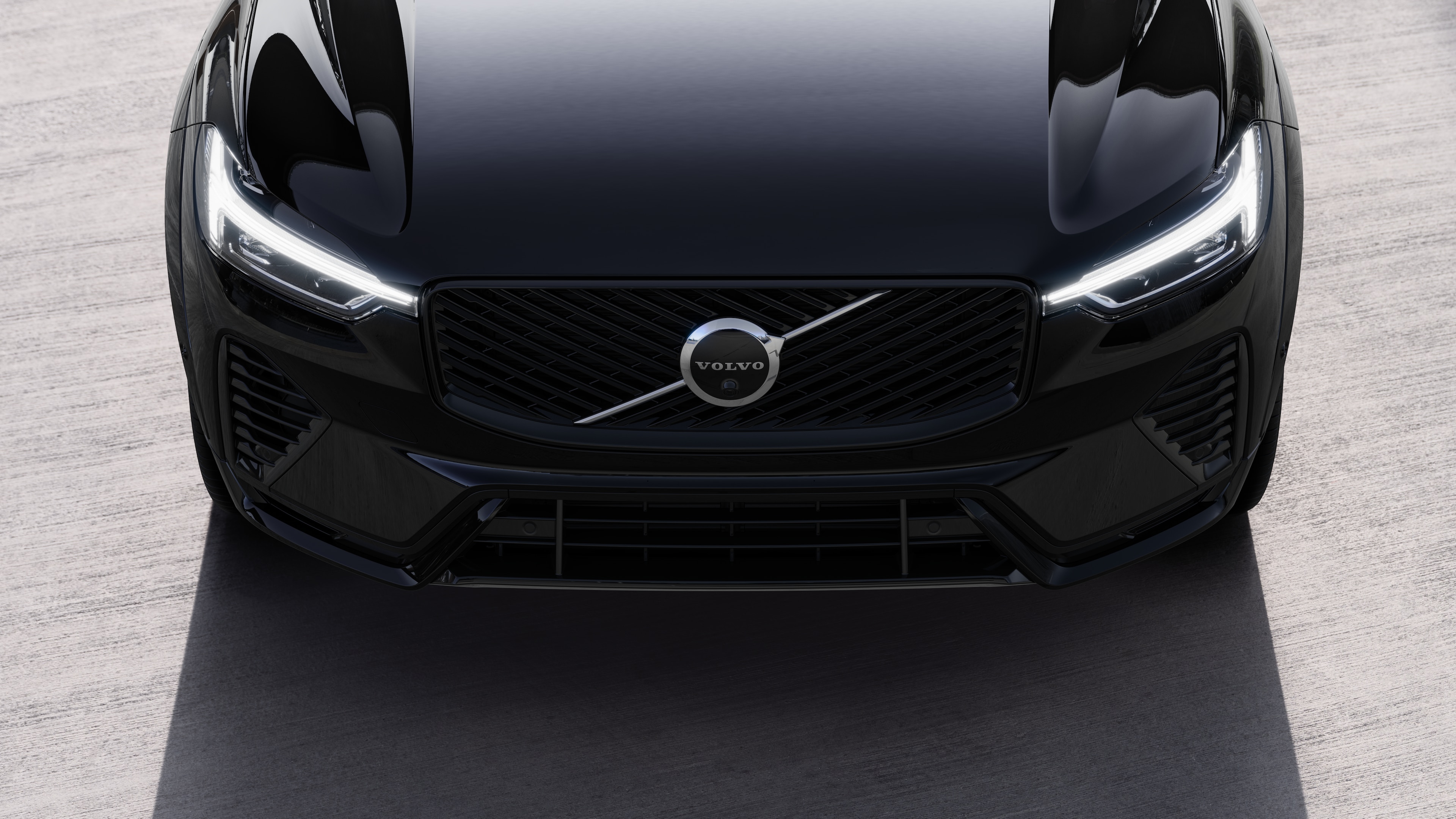 Volvo car exterior in three-quarter view on an urban street background, showing one side, roof, and part of the front.