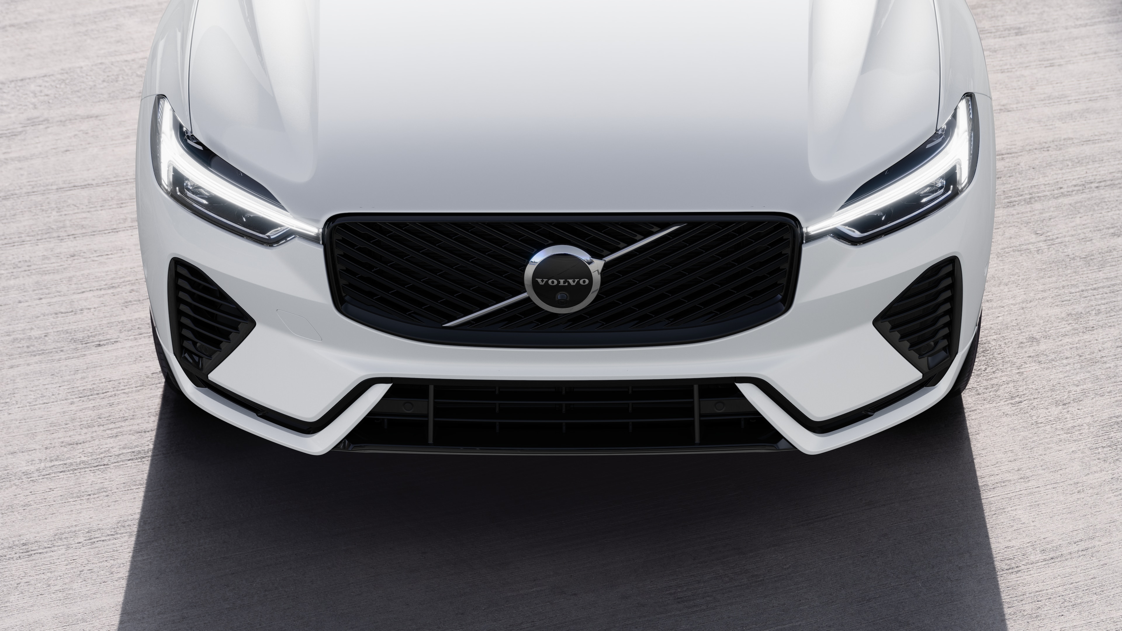 Volvo car exterior in three-quarter view on an urban street background, showing one side, roof, and part of the front.