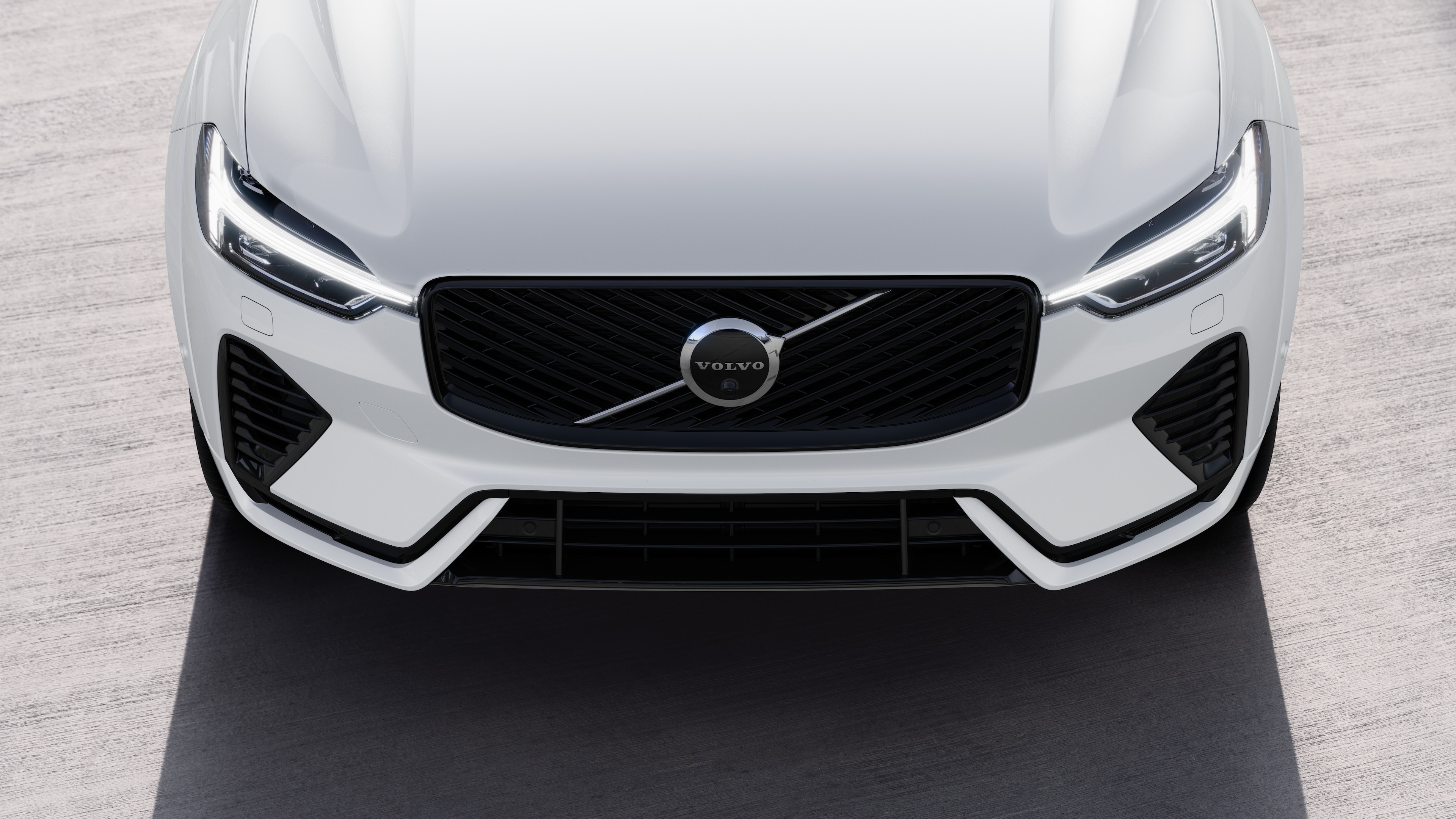 Volvo car exterior in three-quarter view on an urban street background, showing one side, roof, and part of the front.