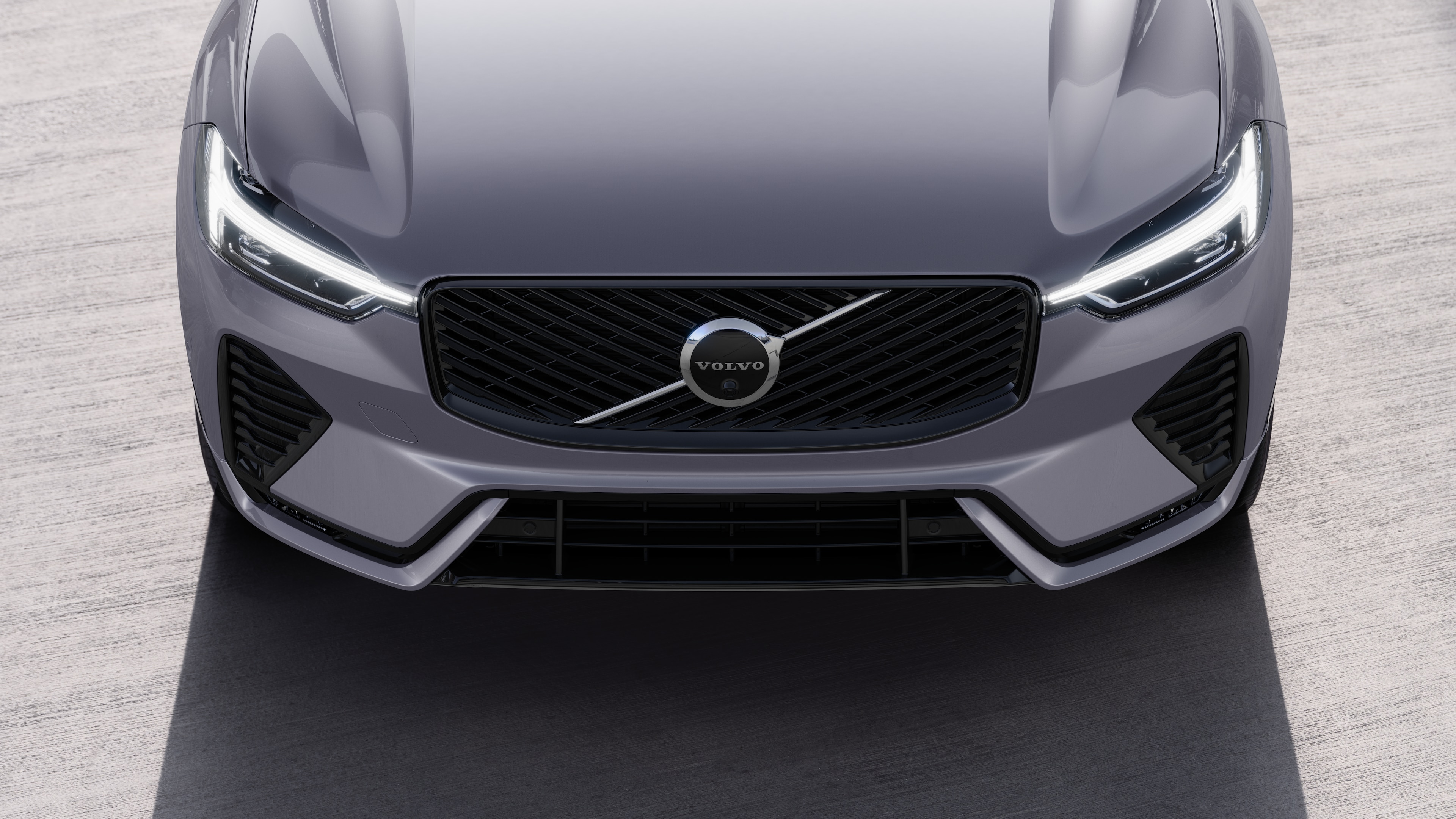 Volvo car exterior in three-quarter view on an urban street background, showing one side, roof, and part of the front.