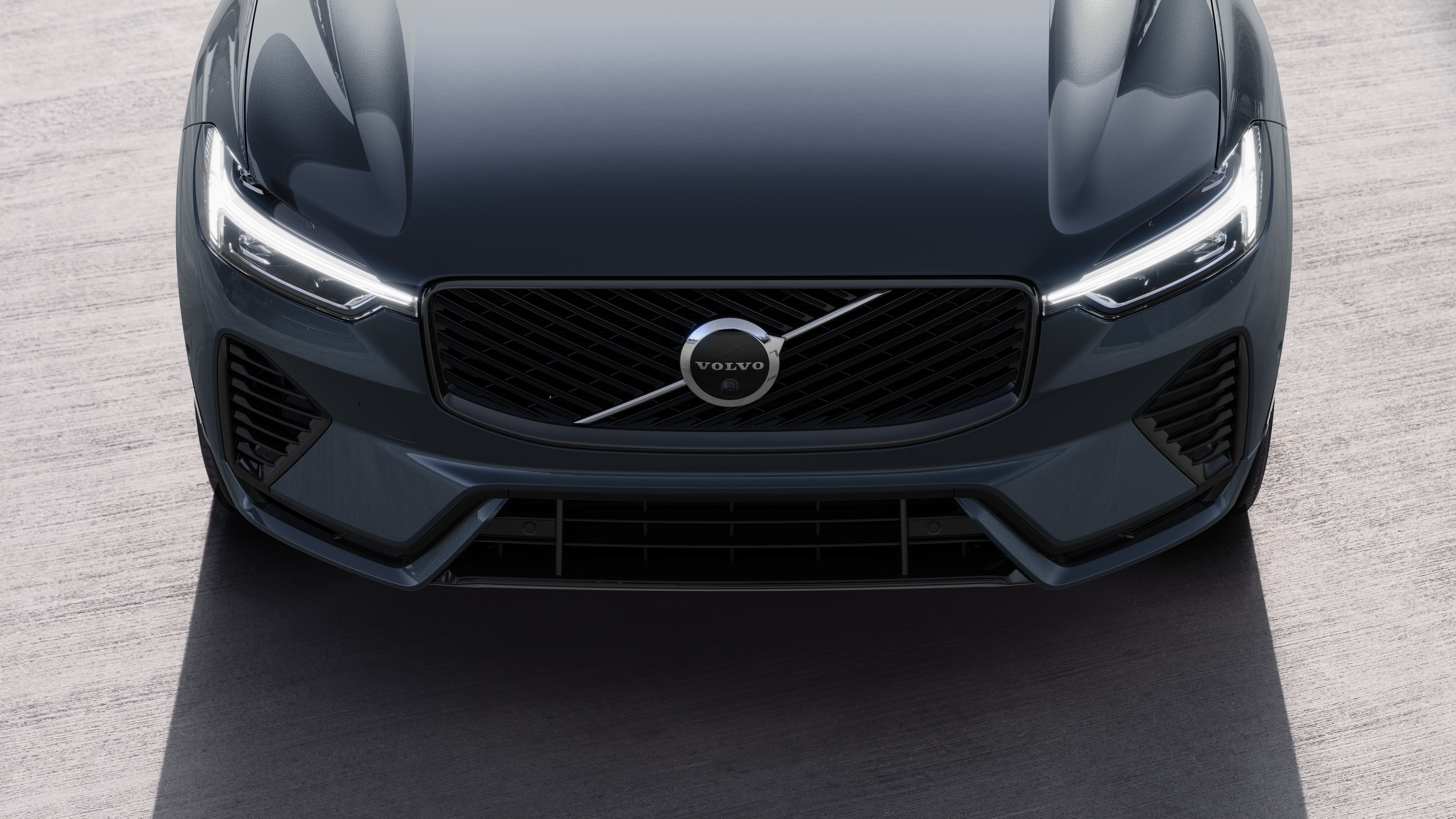 Volvo car exterior in three-quarter view on an urban street background, showing one side, roof, and part of the front.