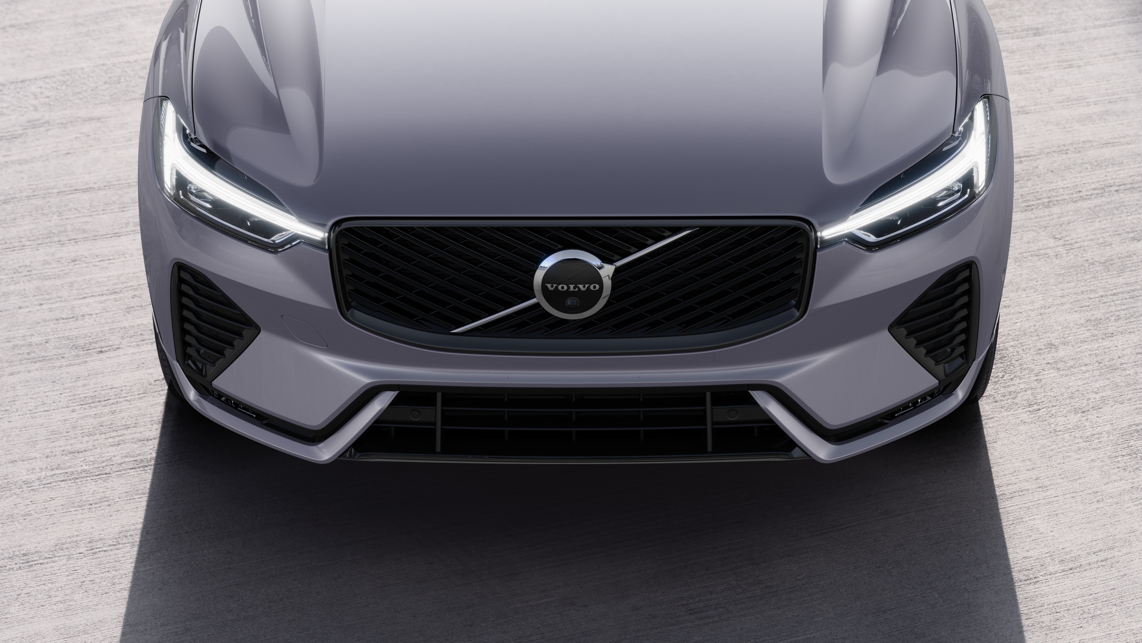 Volvo car exterior in three-quarter view on an urban street background, showing one side, roof, and part of the front.