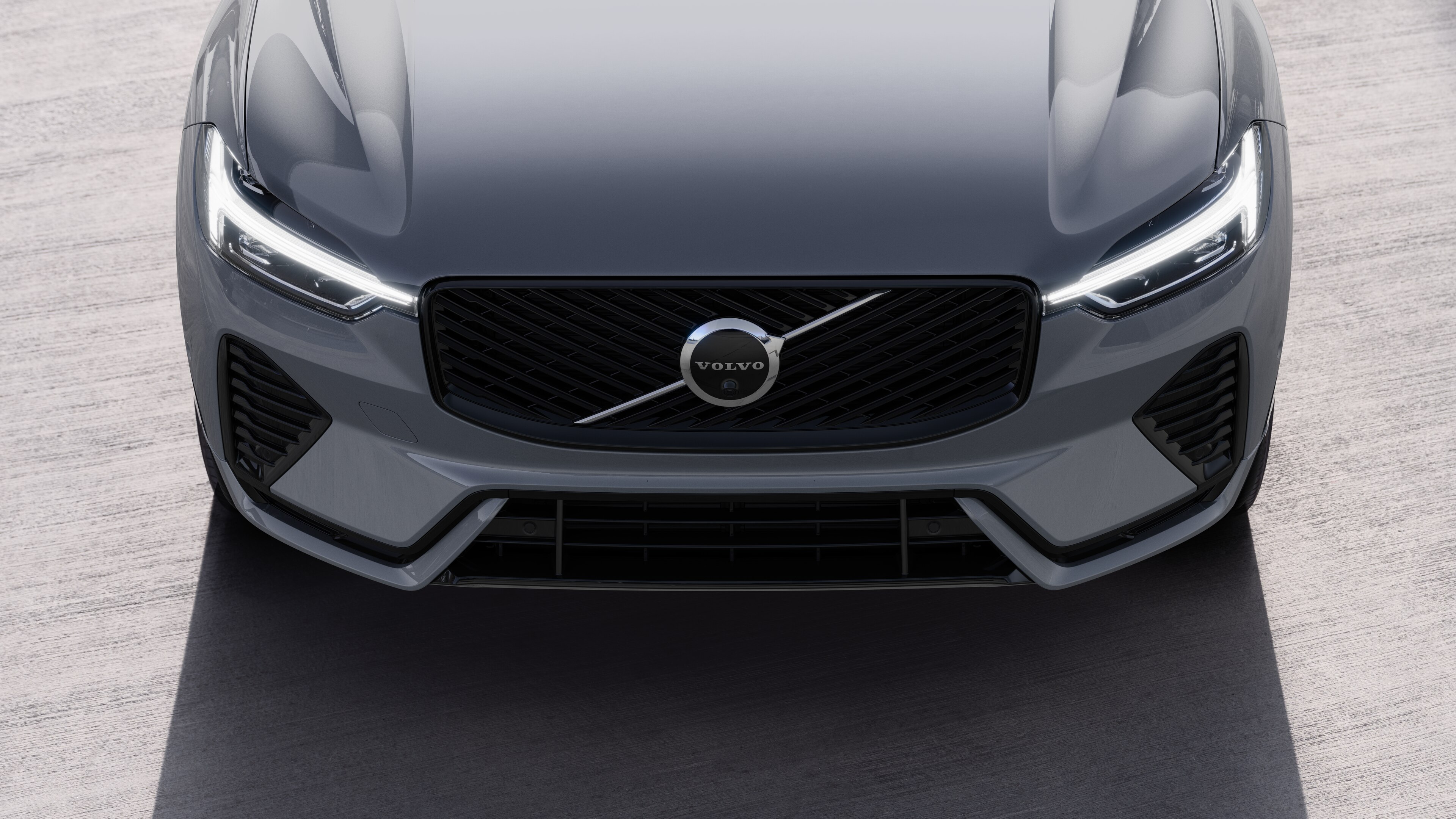 Volvo car exterior in three-quarter view on an urban street background, showing one side, roof, and part of the front.