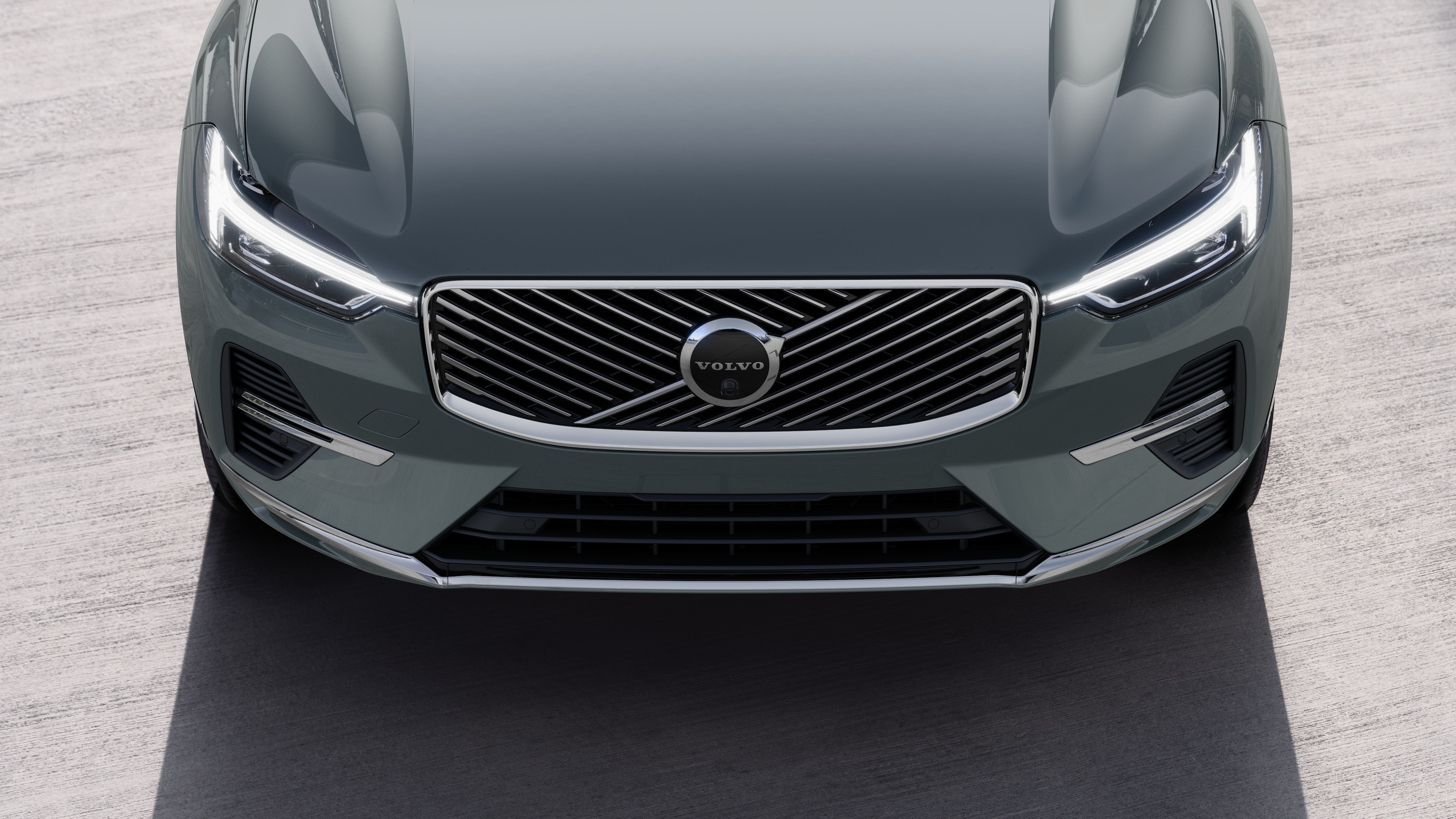 Volvo car exterior in three-quarter view on an urban street background, showing one side, roof, and part of the front.