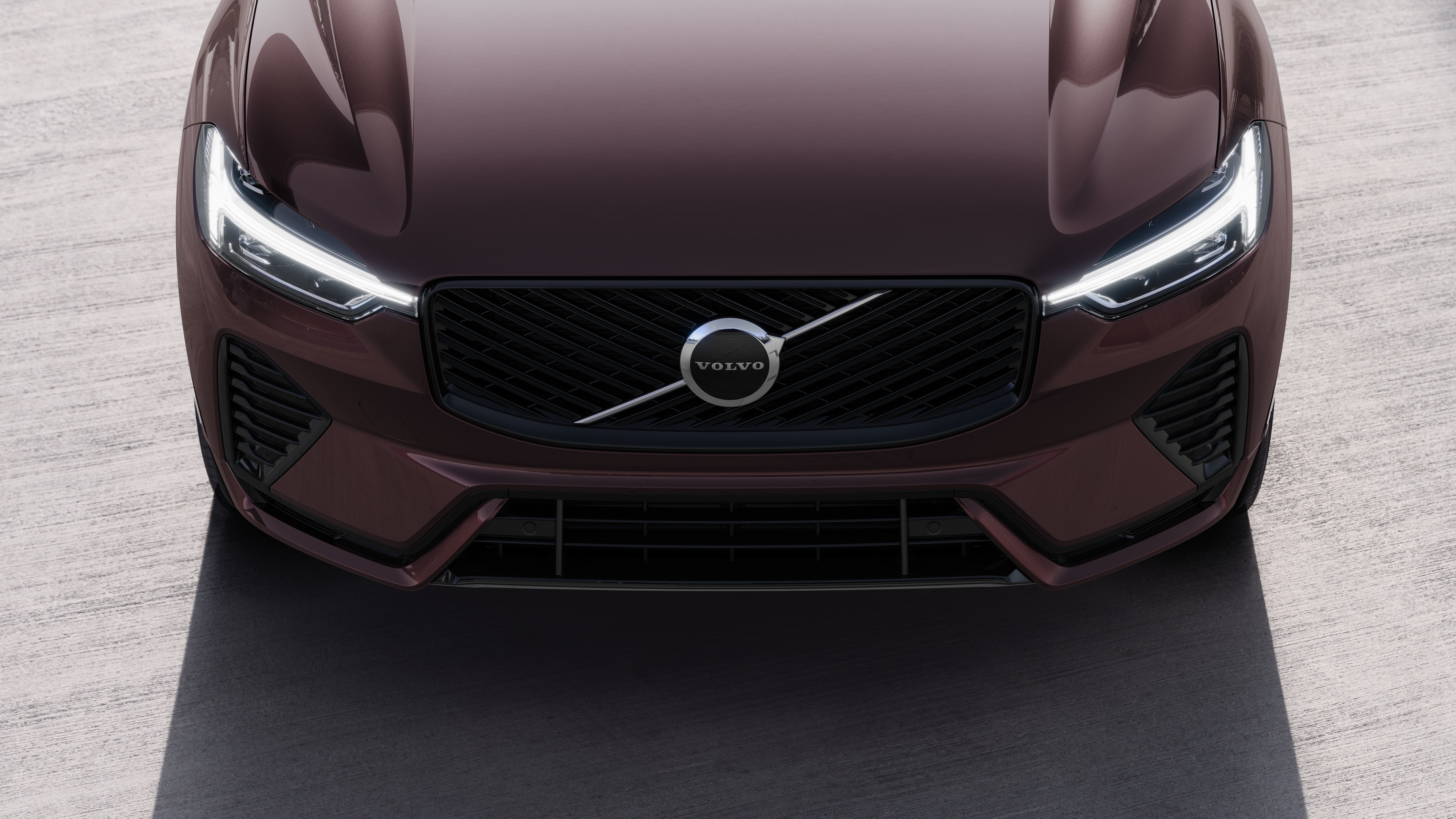 Volvo automašīnas ārpuse trīs ceturtdaļu skatā uz pilsētas ielas fona, parādot vienu pusi, jumtu un daļu priekšpuses.