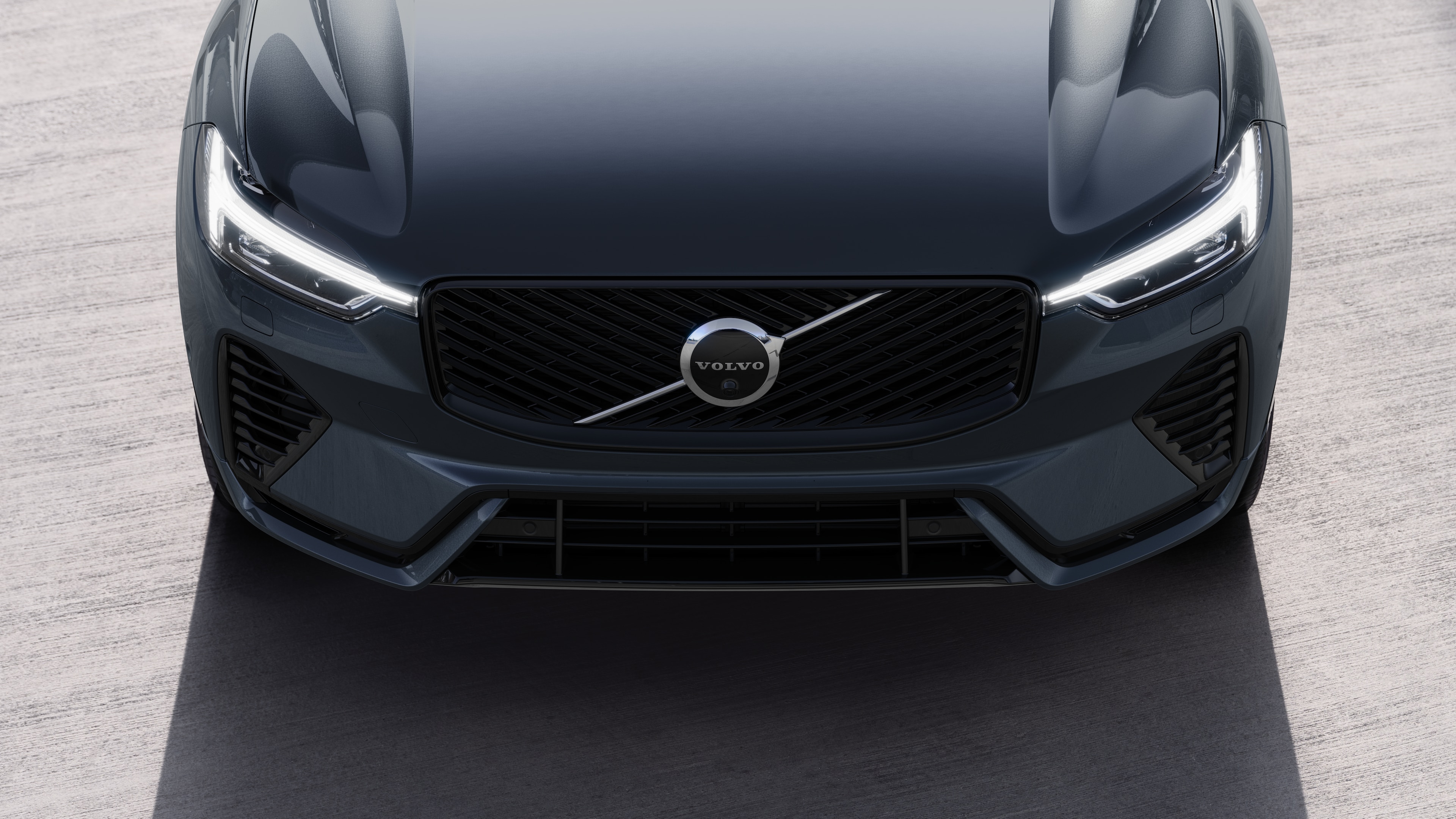 Volvo car exterior in three-quarter view on an urban street background, showing one side, roof, and part of the front.