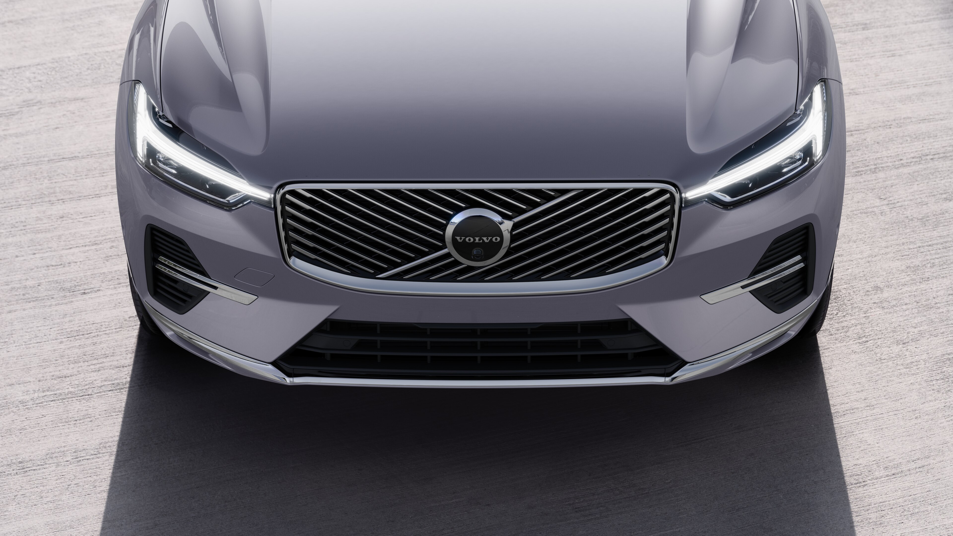 منظر خارجي لسيارة فولفو من ثلاثة أرباع سيارة فولفو على خلفية شارع حضري، يظهر جانبا واحدا وسقفا وجزءا من المقدمة.