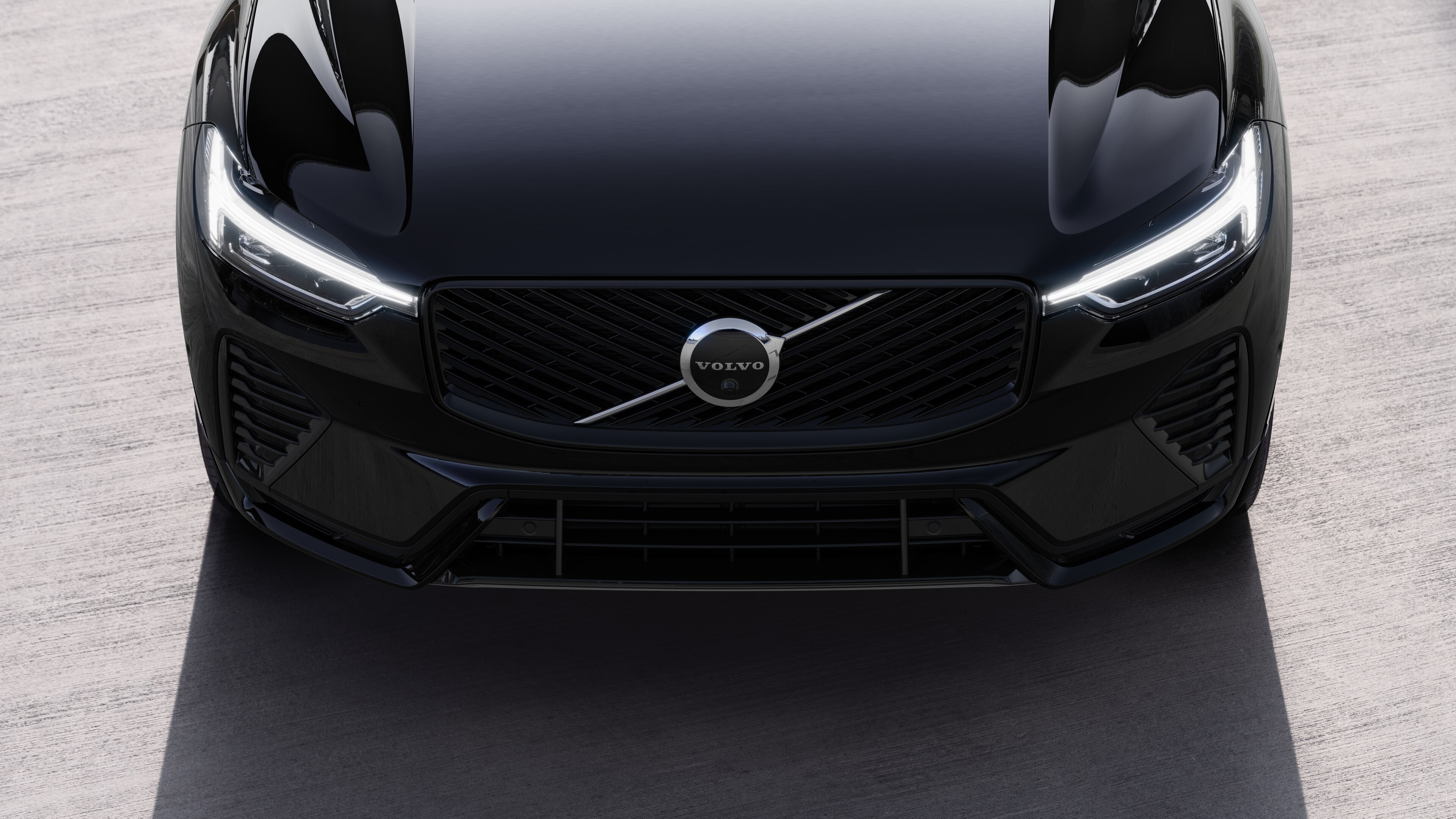 Volvo car exterior in three-quarter view on an urban street background, showing one side, roof, and part of the front.