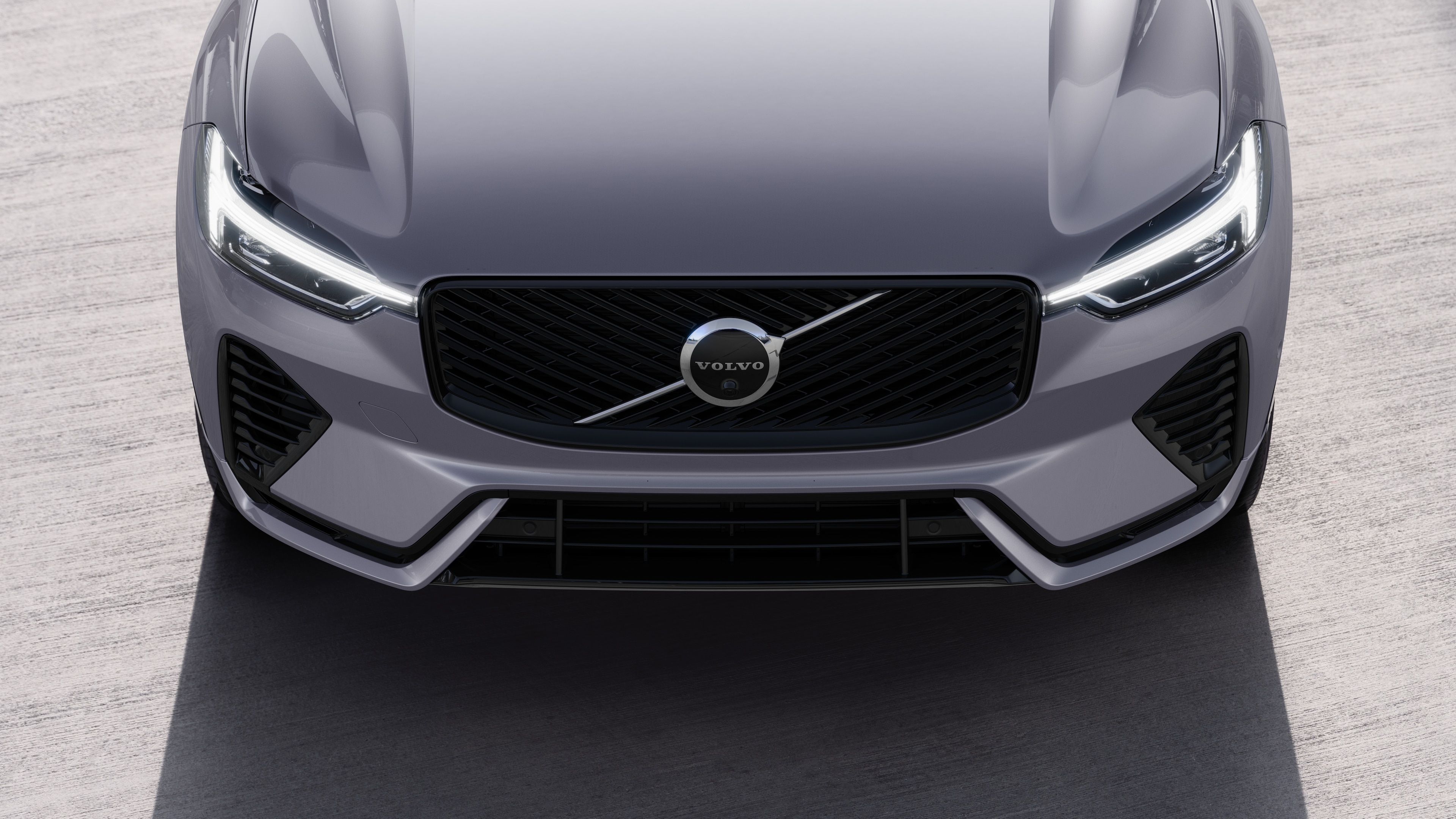 Volvo car exterior in three-quarter view on an urban street background, showing one side, roof, and part of the front.