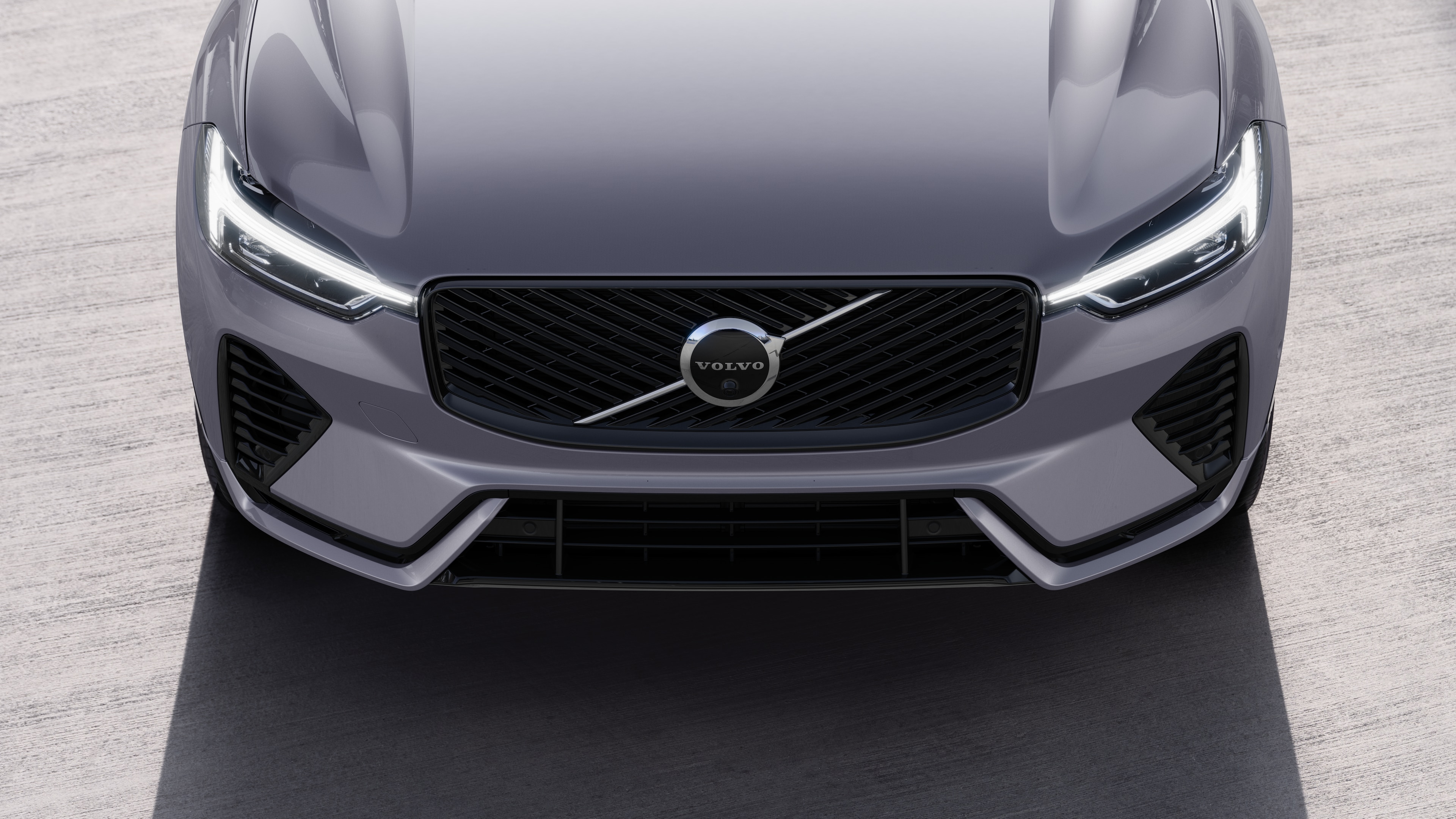 Volvo car exterior in three-quarter view on an urban street background, showing one side, roof, and part of the front.