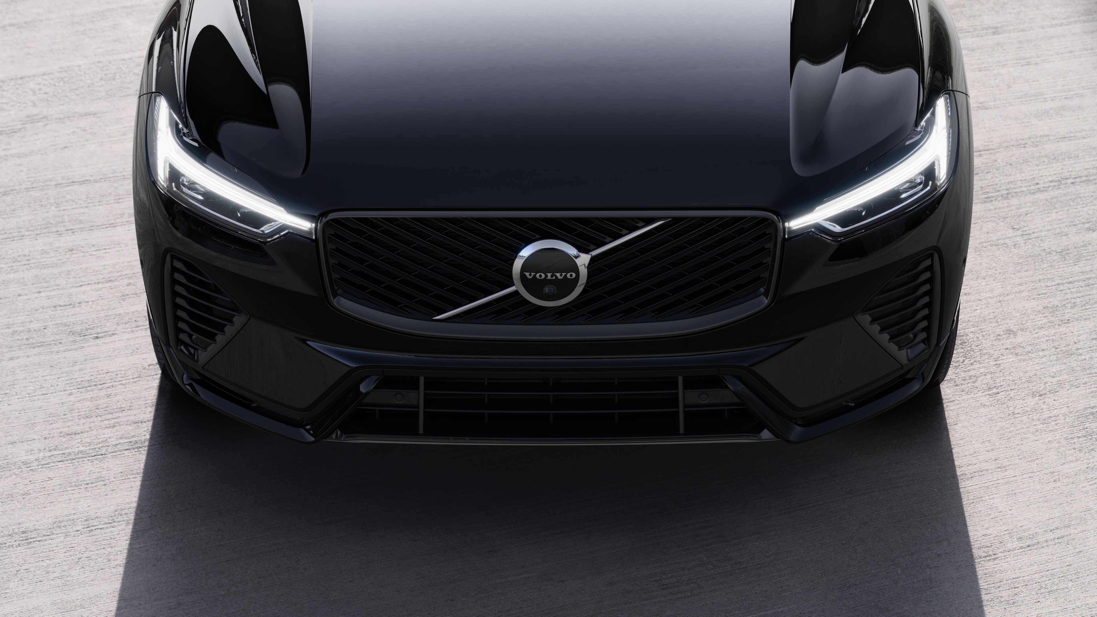 Volvo car exterior in three-quarter view on an urban street background, showing one side, roof, and part of the front.