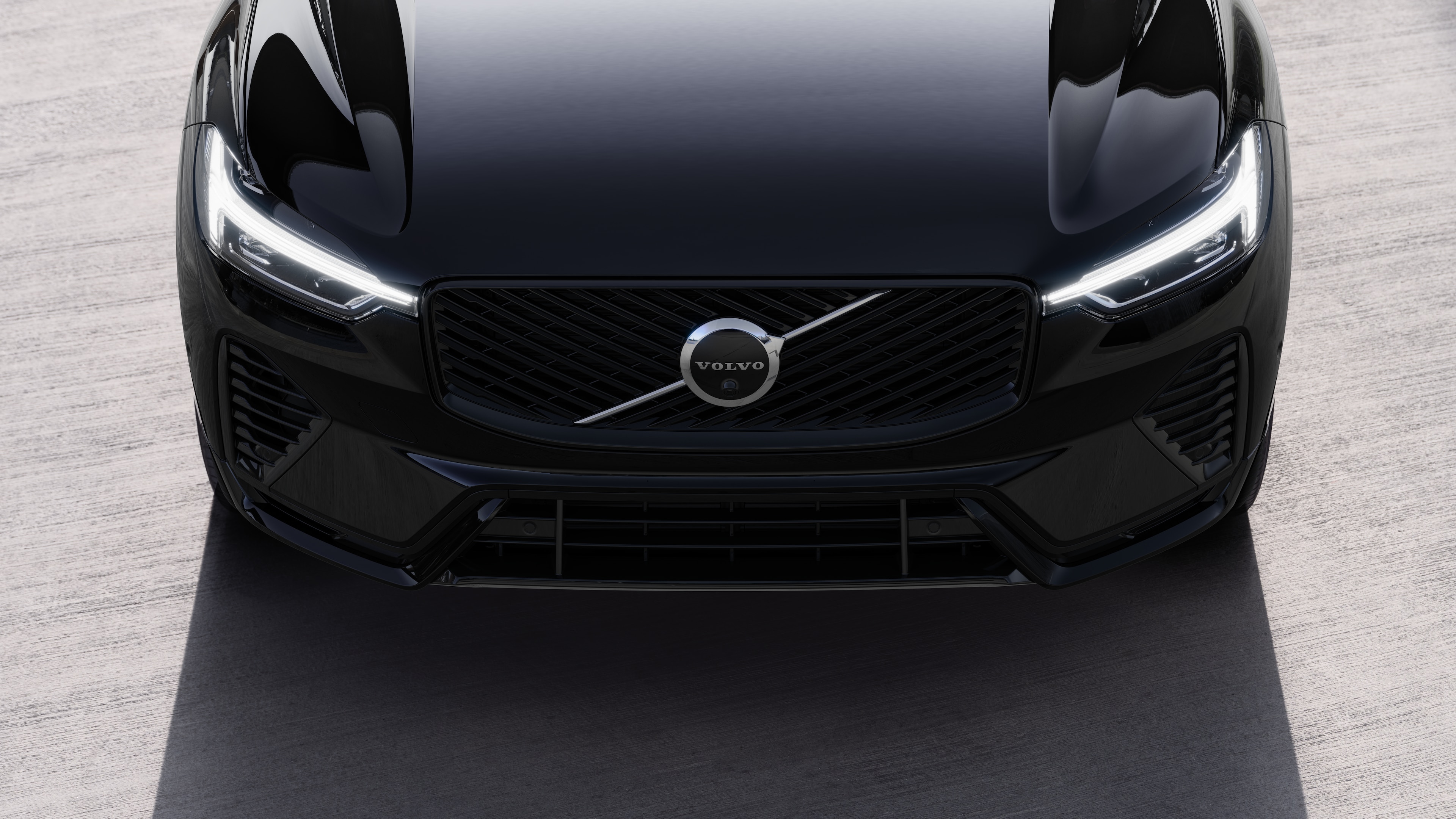 Volvo car exterior in three-quarter view on an urban street background, showing one side, roof, and part of the front.