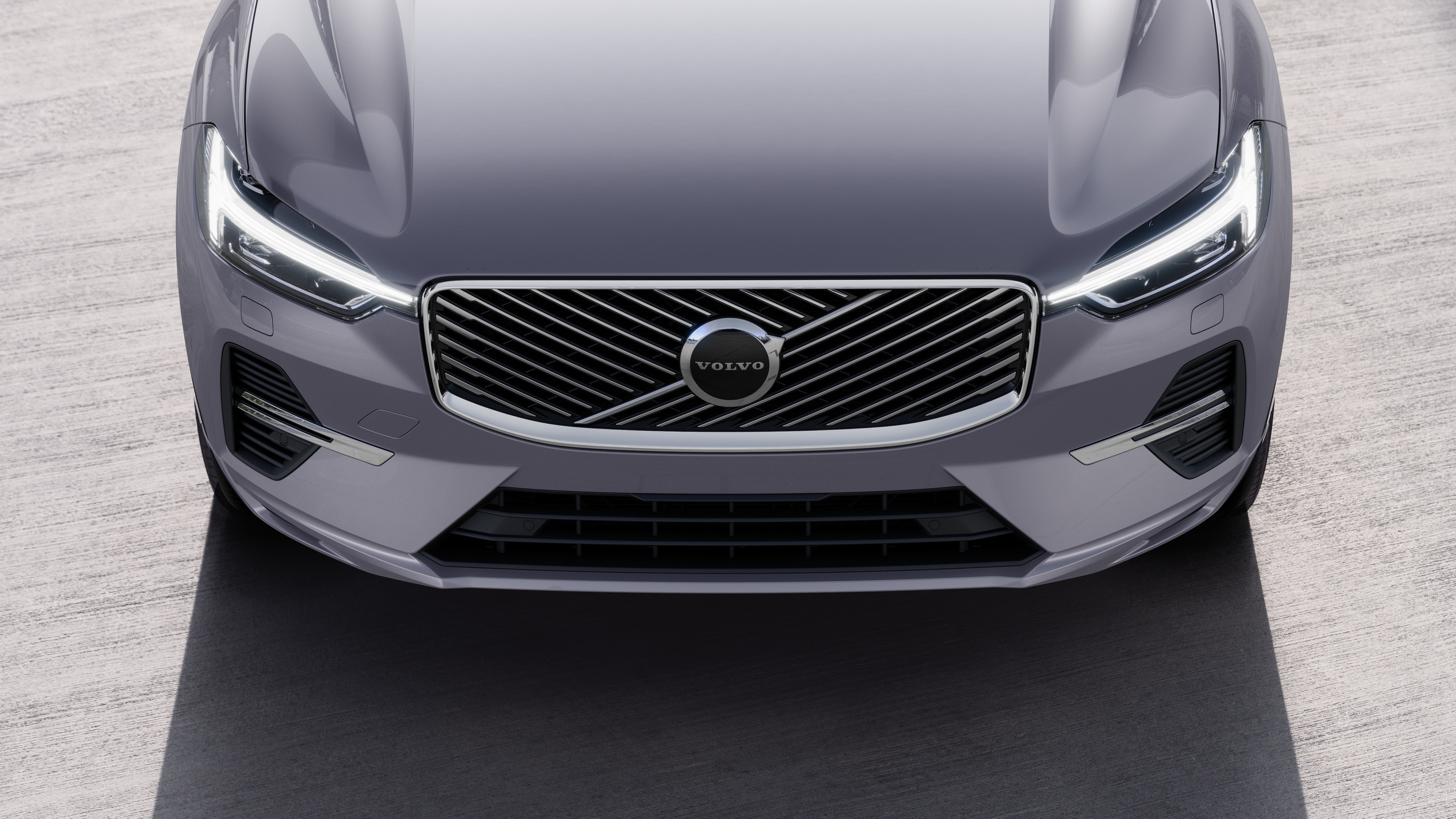 Volvobilens exteriör i trekvartsvy mot en urban gatubakgrund, som visar ena sidan, taket och en del av fronten.