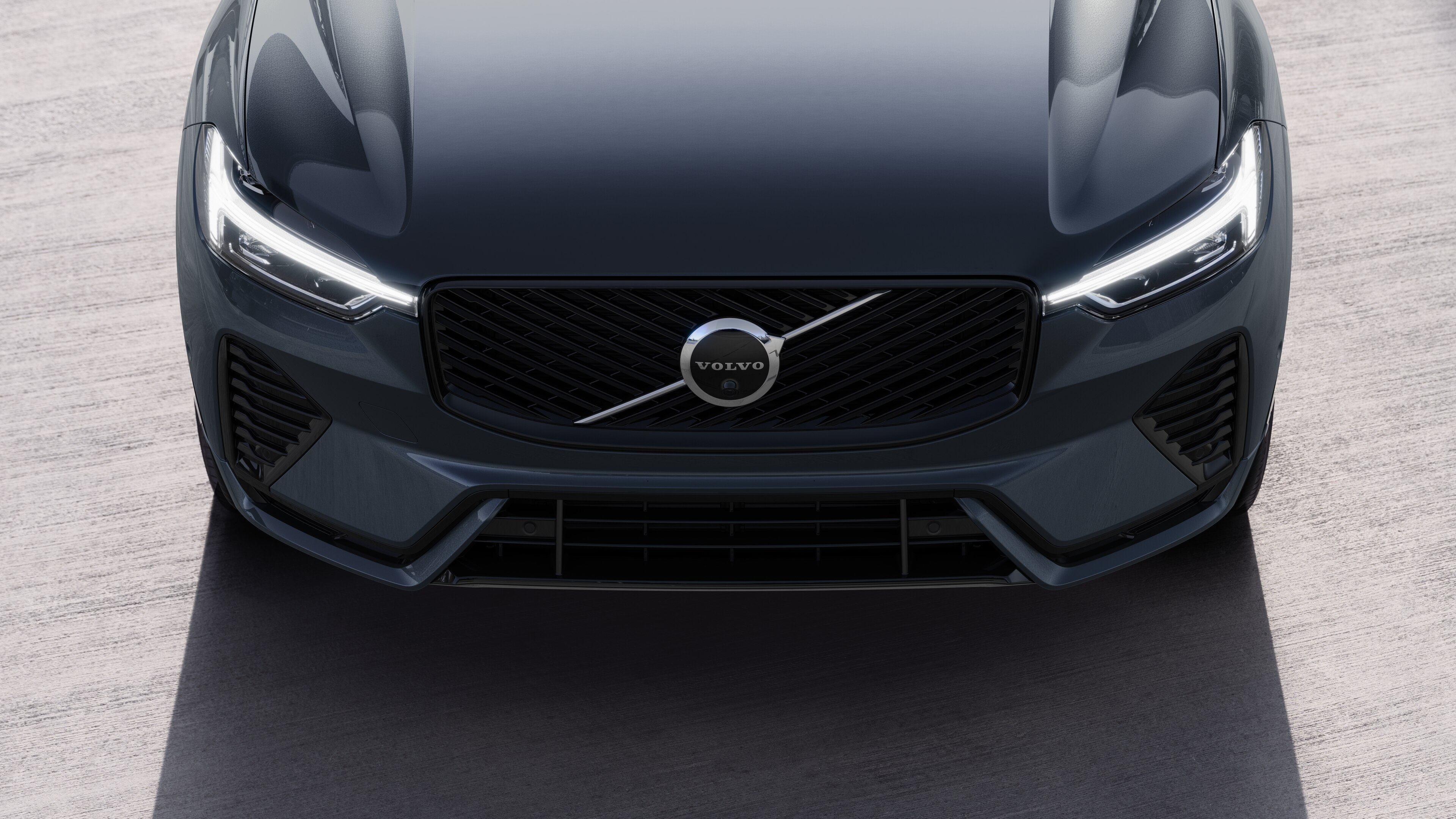 Volvo car exterior in three-quarter view on an urban street background, showing one side, roof, and part of the front.