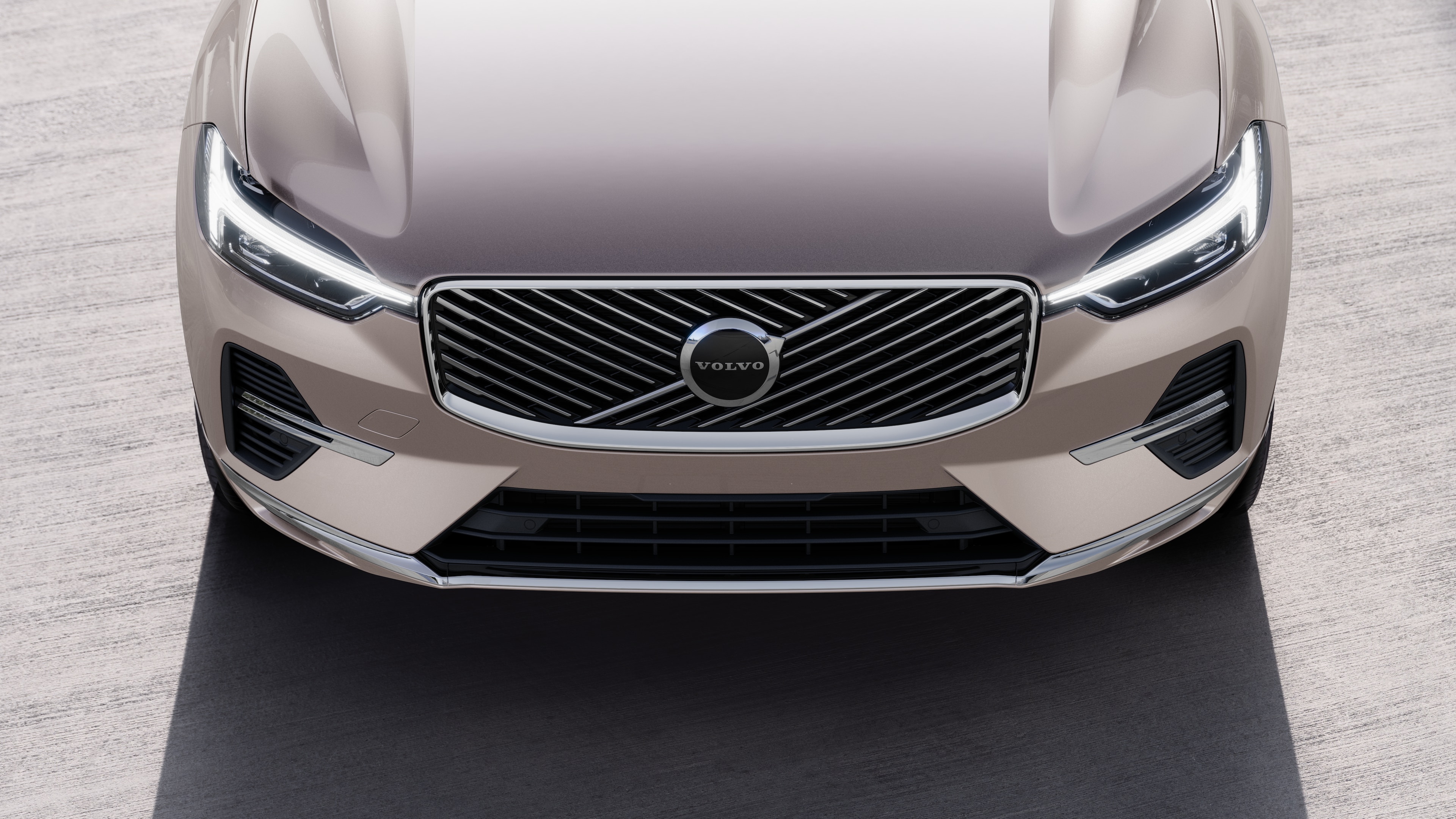 Exterior do carro Volvo em vista de três quartos em um fundo de rua urbana, mostrando um lado, teto e parte da frente.