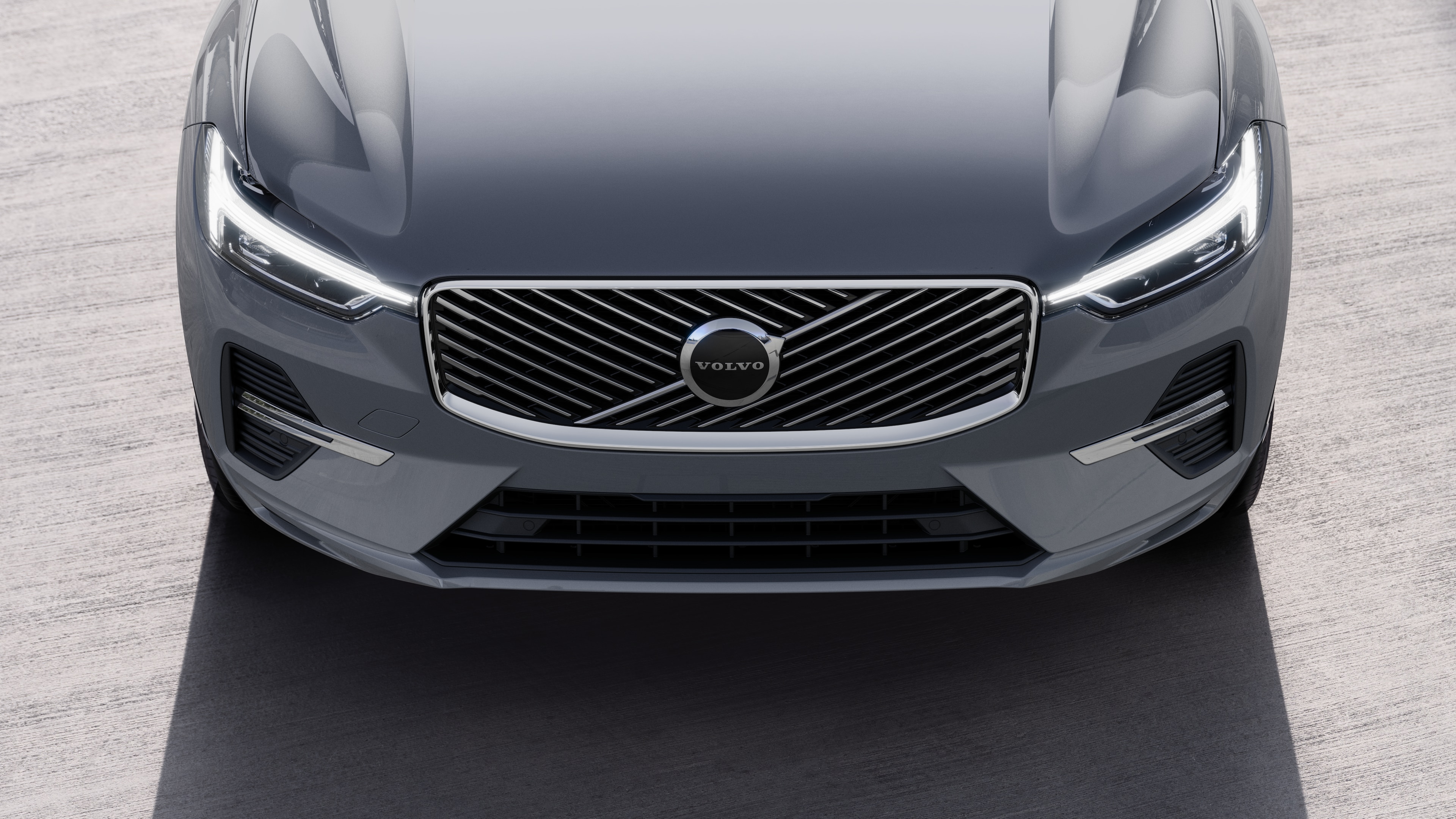 Tříčtvrteční pohled na exteriér vozu Volvo na pozadí městské ulice, kde je vidět jedna strana, střecha a část přídi.