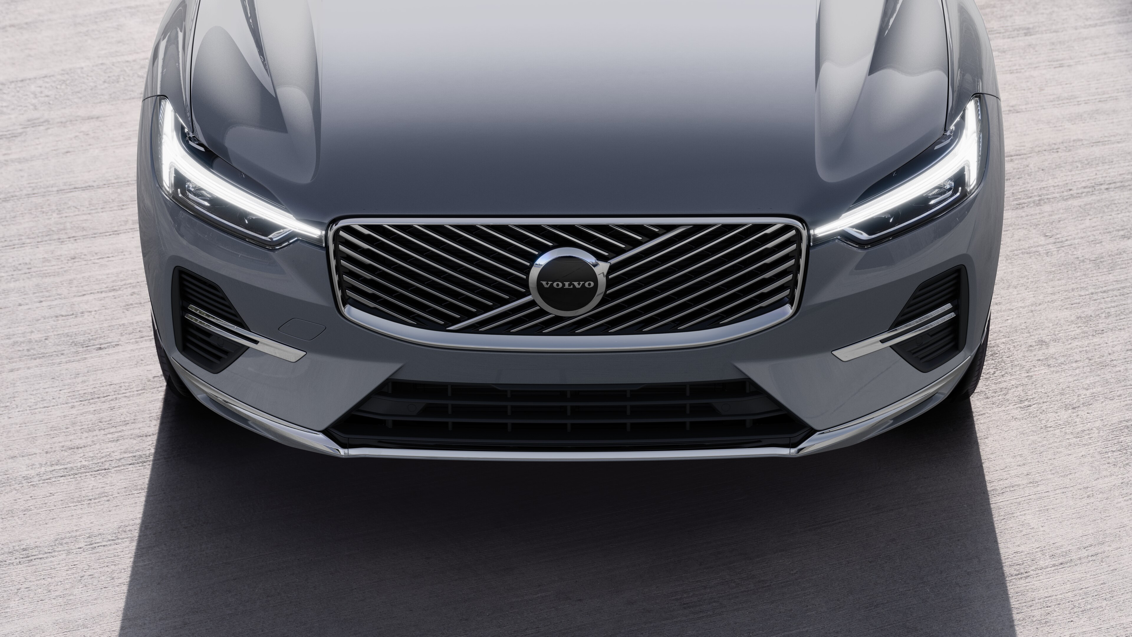 Volvo მანქანის ექსტერიერი სამი მეოთხედი ხედით ურბანული ქუჩის ფონზე, რომელიც აჩვენებს ერთ მხარეს, სახურავს და ფრონტის ნაწილს.