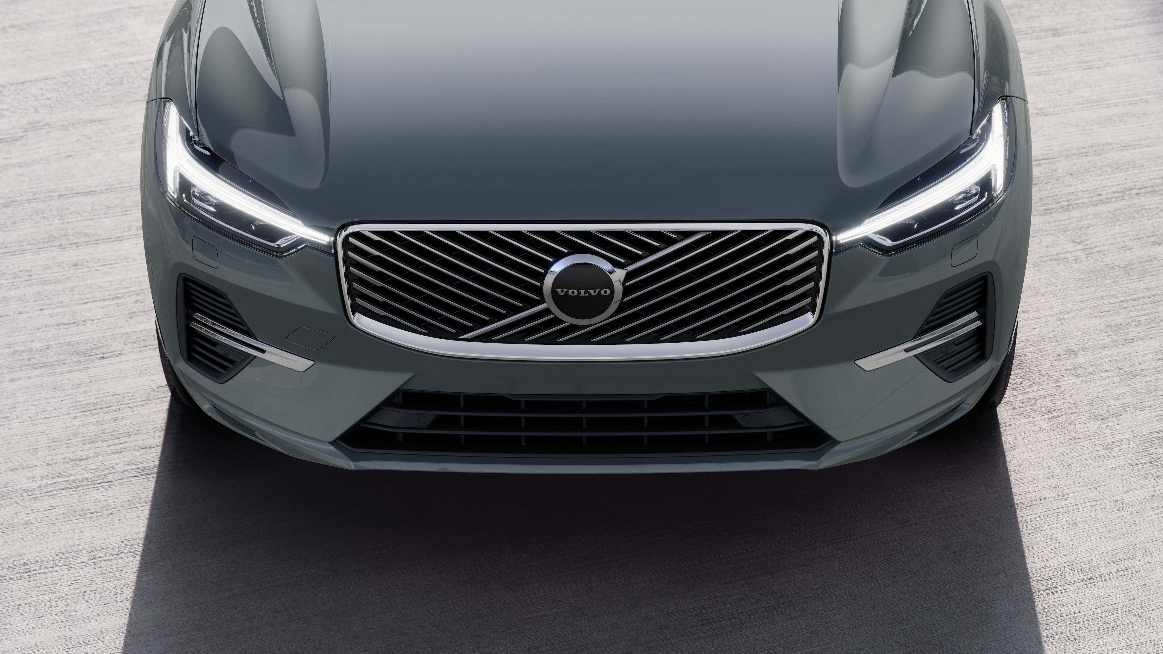 Volvobilens exteriör i trekvartsvy mot en urban gatubakgrund, som visar ena sidan, taket och en del av fronten.