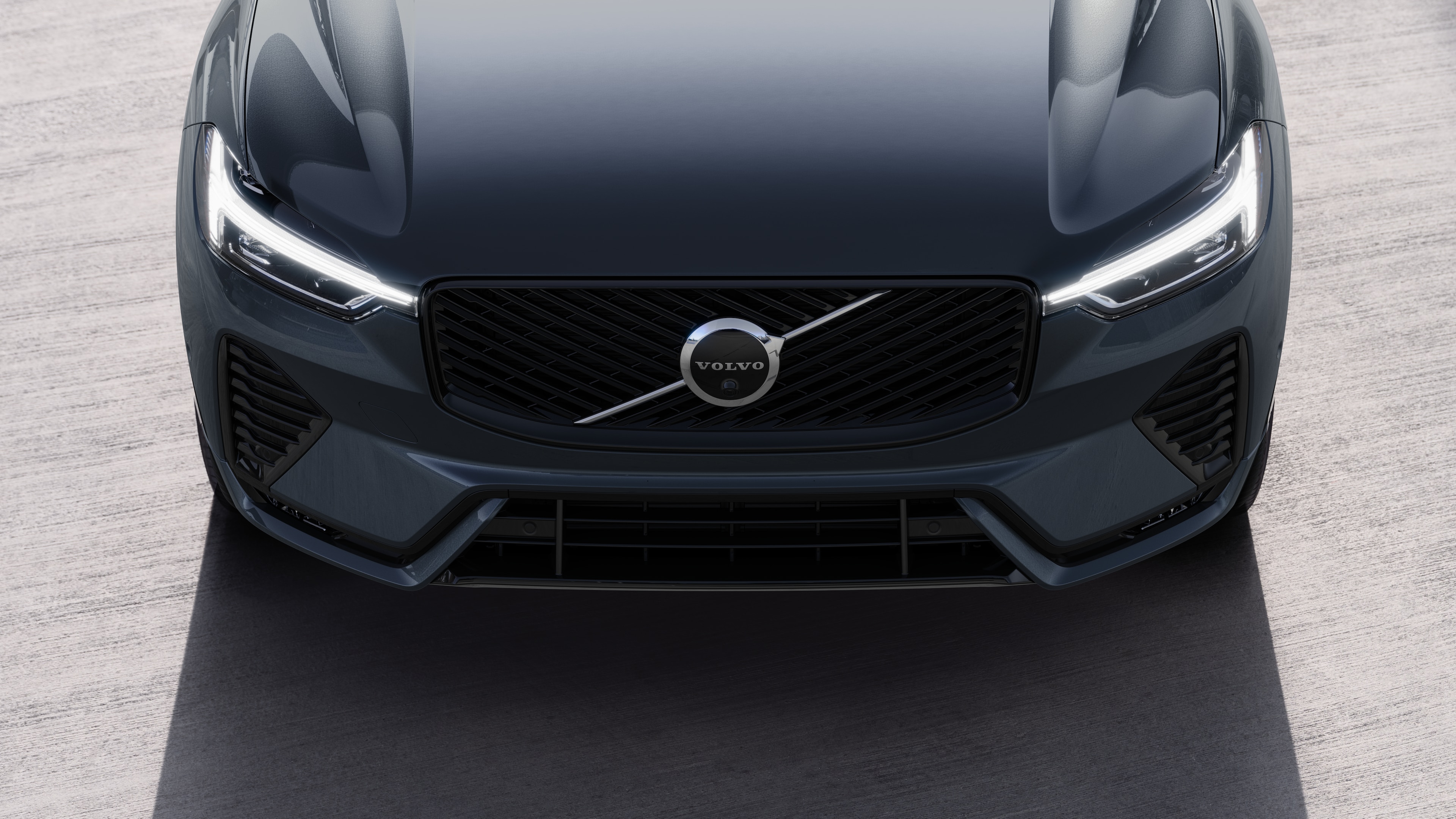 Volvo car exterior in three-quarter view on an urban street background, showing one side, roof, and part of the front.