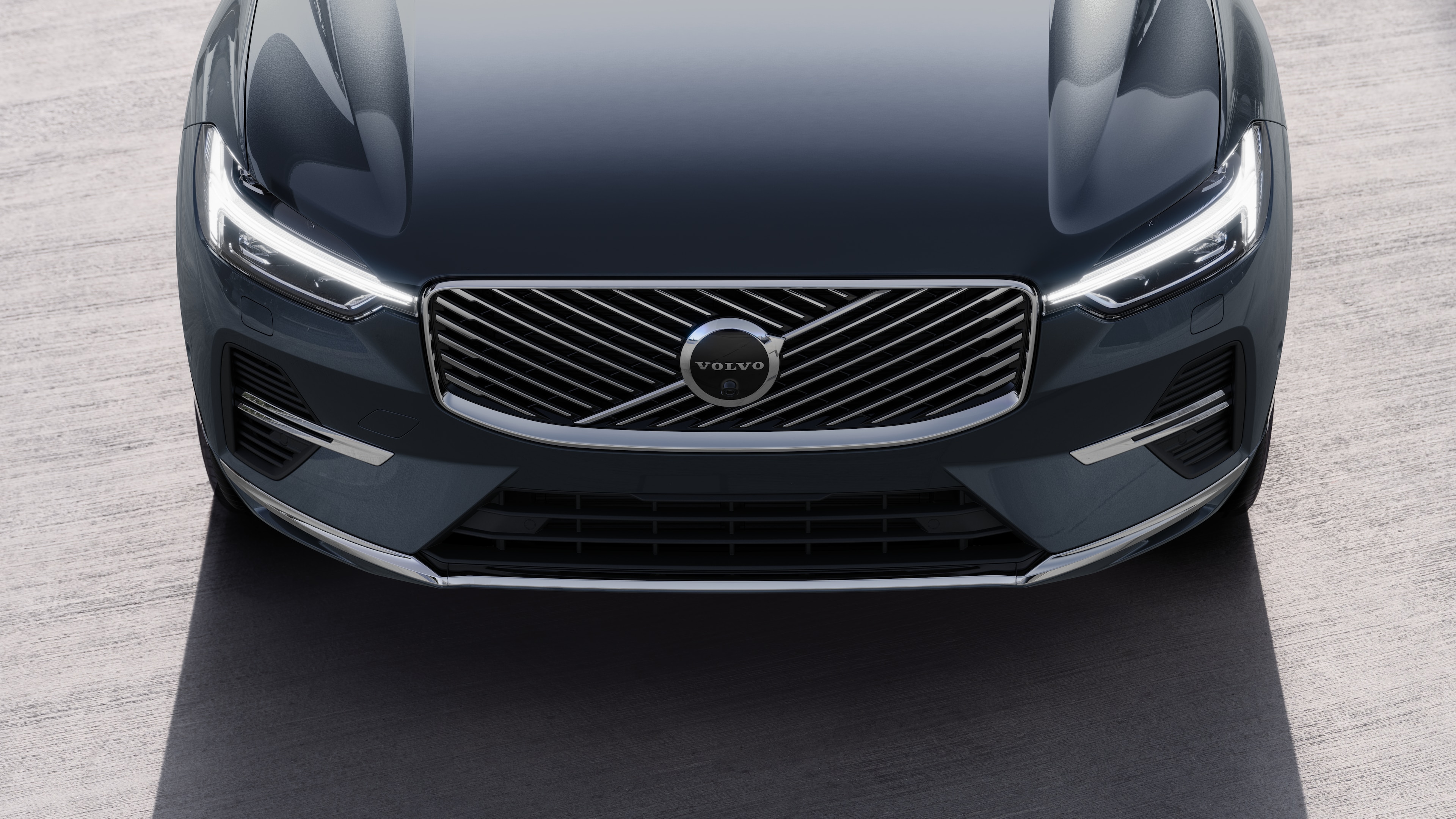 Volvo car exterior in three-quarter view on an urban street background, showing one side, roof, and part of the front.