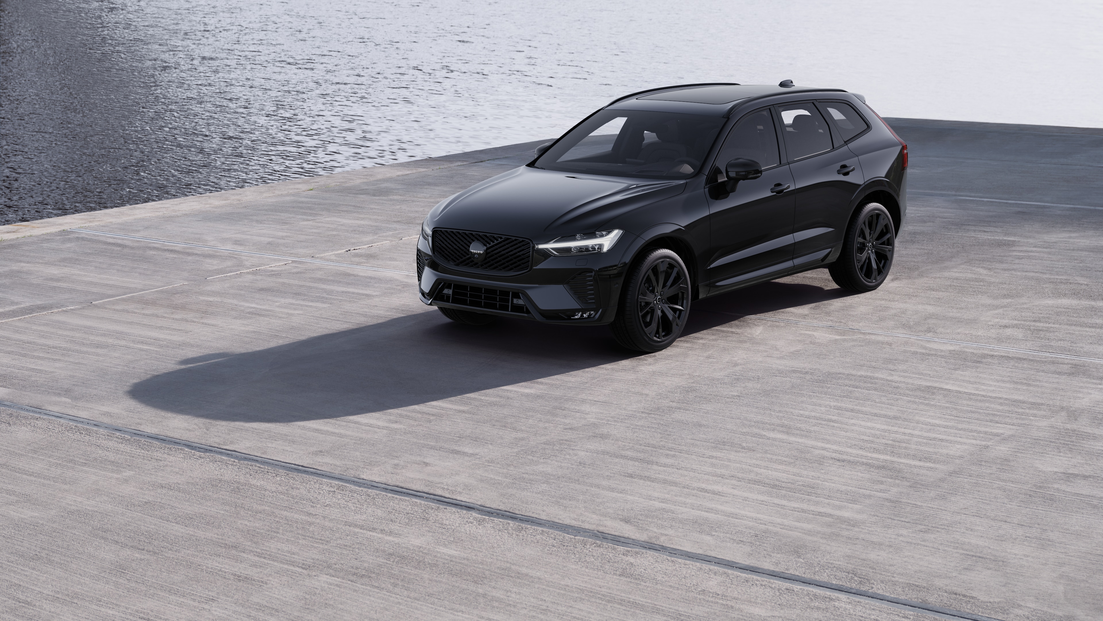 Zunanjost avtomobila Volvo s tričetrtinskim pogledom na ozadje industrijskega betonskega zidu.