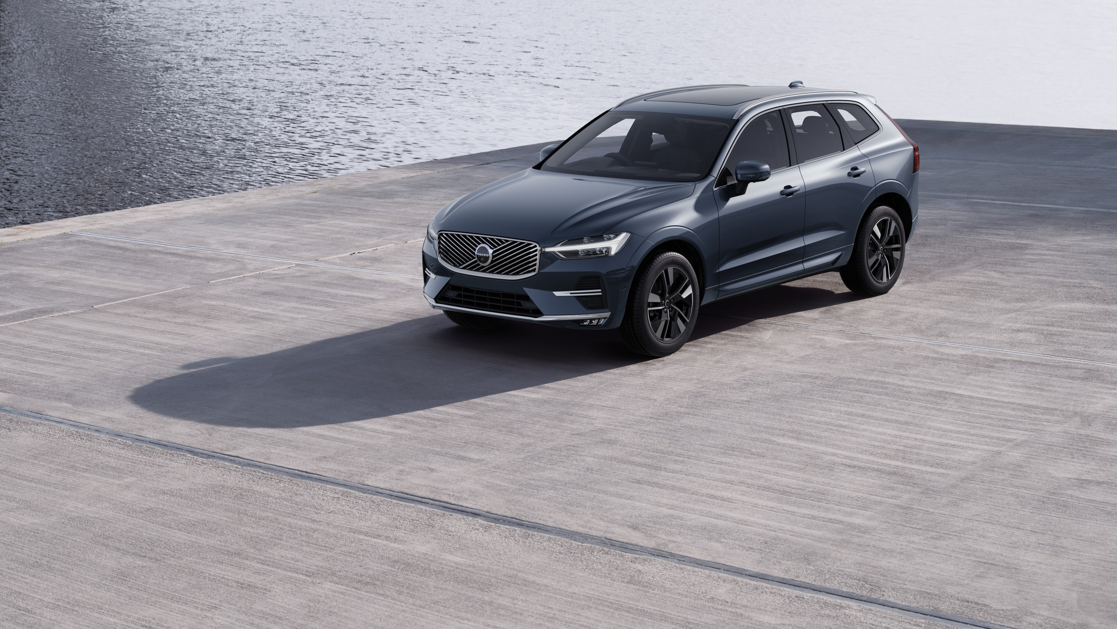 Volvo car exterior in three-quarter view against an industrial concrete wall background.