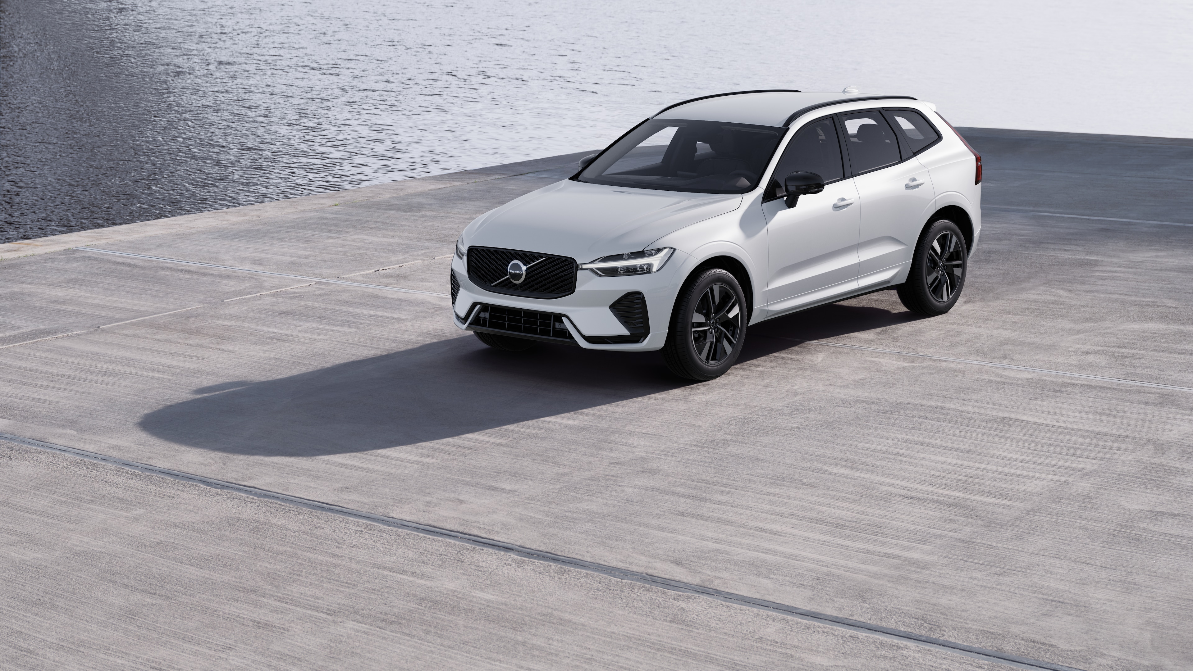 Volvo automašīnas ārpuse trīs ceturtdaļu skatā uz industriālā betona sienas fona.