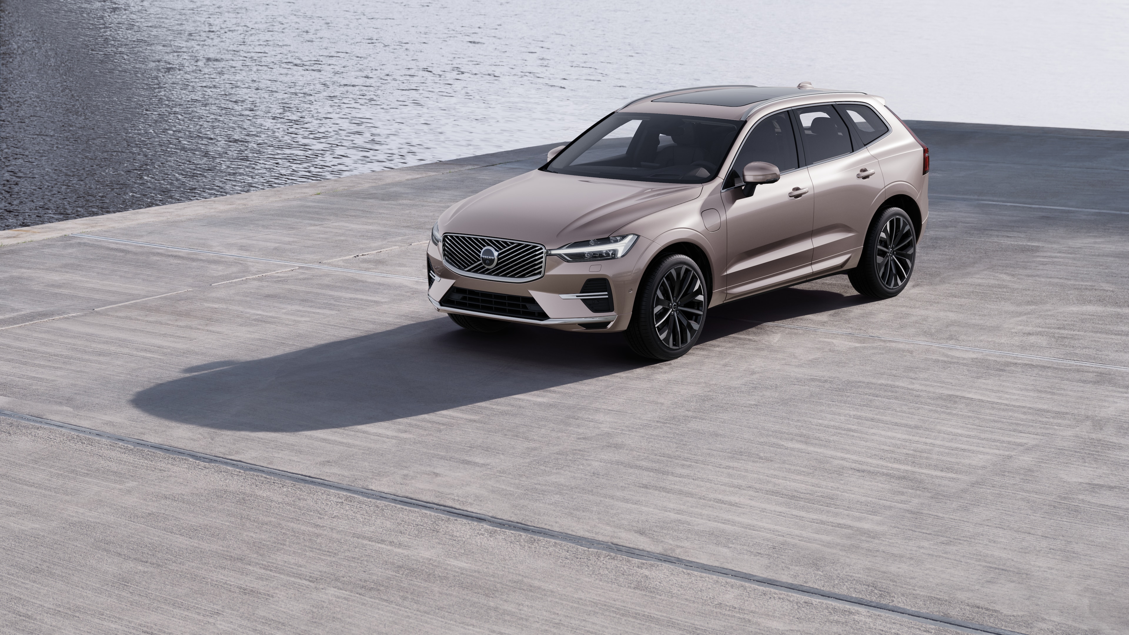 De buitenkant van een Volvo-auto in driekwartaanzicht tegen een achtergrond van een industriële betonnen muur.