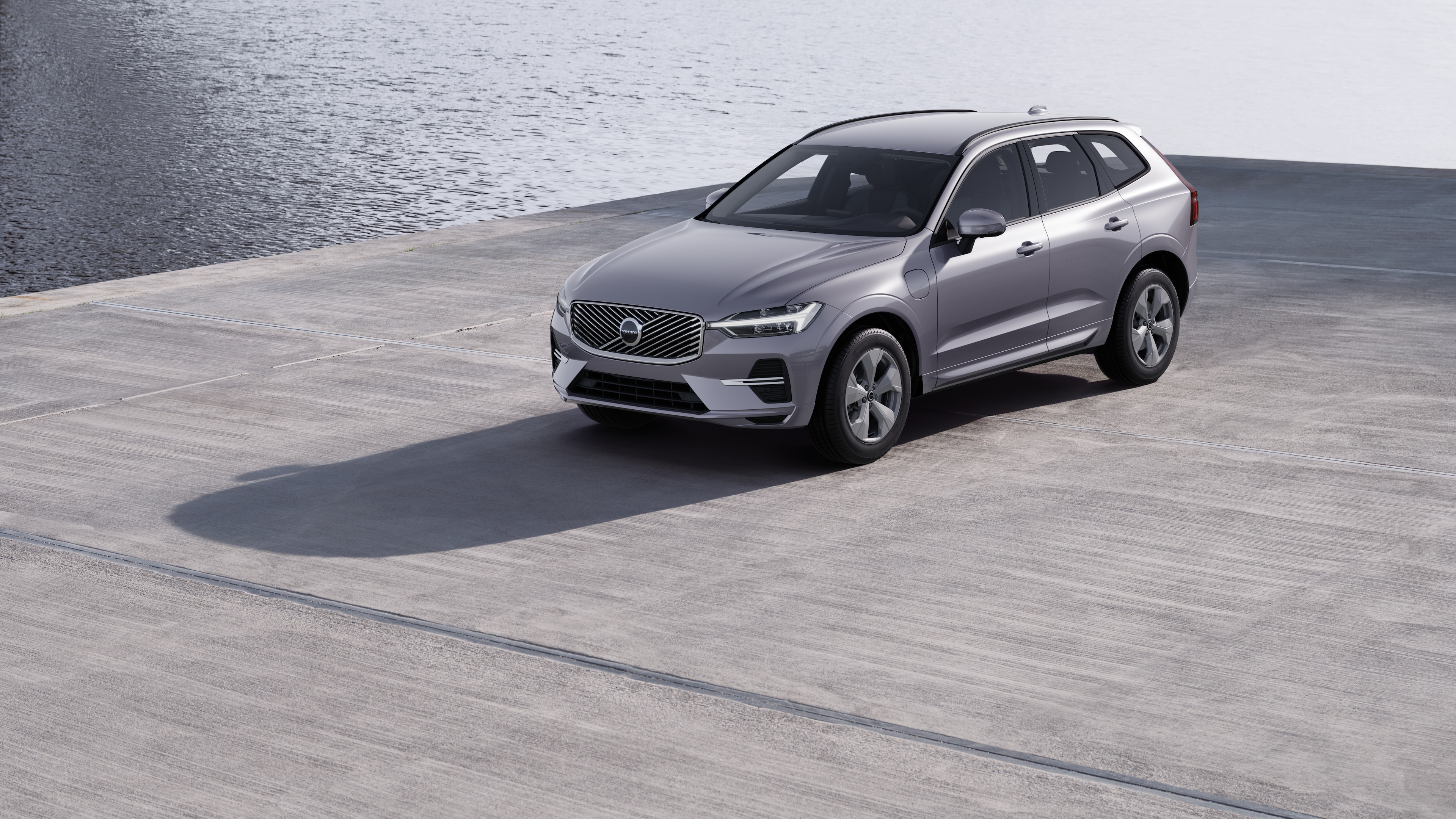 De buitenkant van een Volvo-auto in driekwartaanzicht tegen een achtergrond van een industriële betonnen muur.