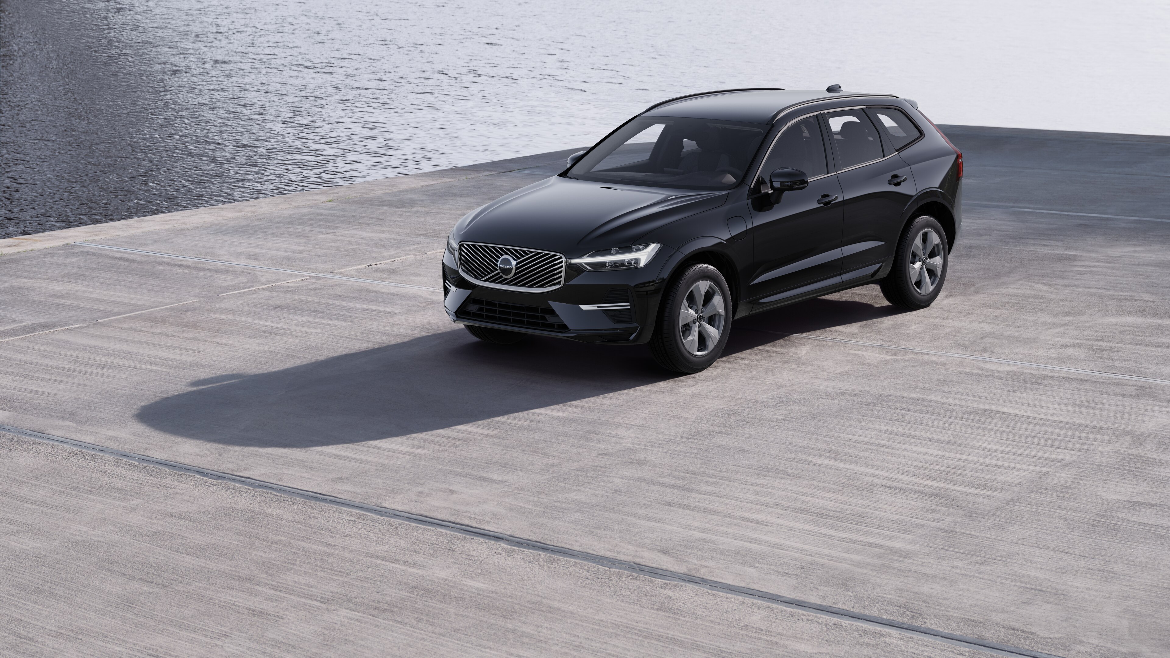 De buitenkant van een Volvo-auto in driekwartaanzicht tegen een achtergrond van een industriële betonnen muur.