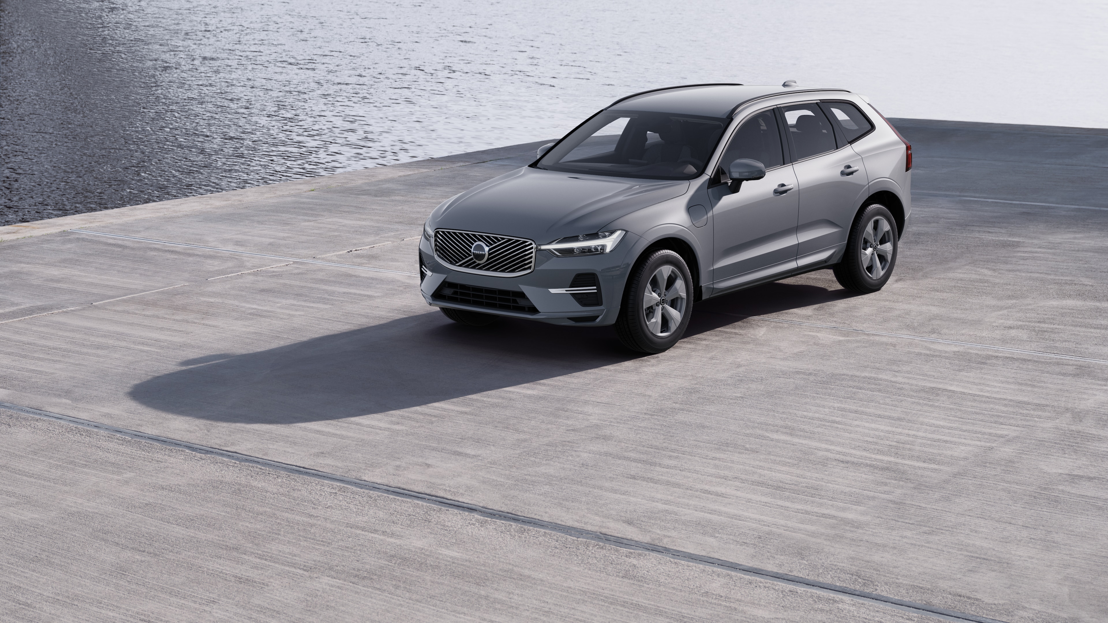 Extérieur d’une Volvo vue de trois quarts sur un fond de mur industriel en béton.