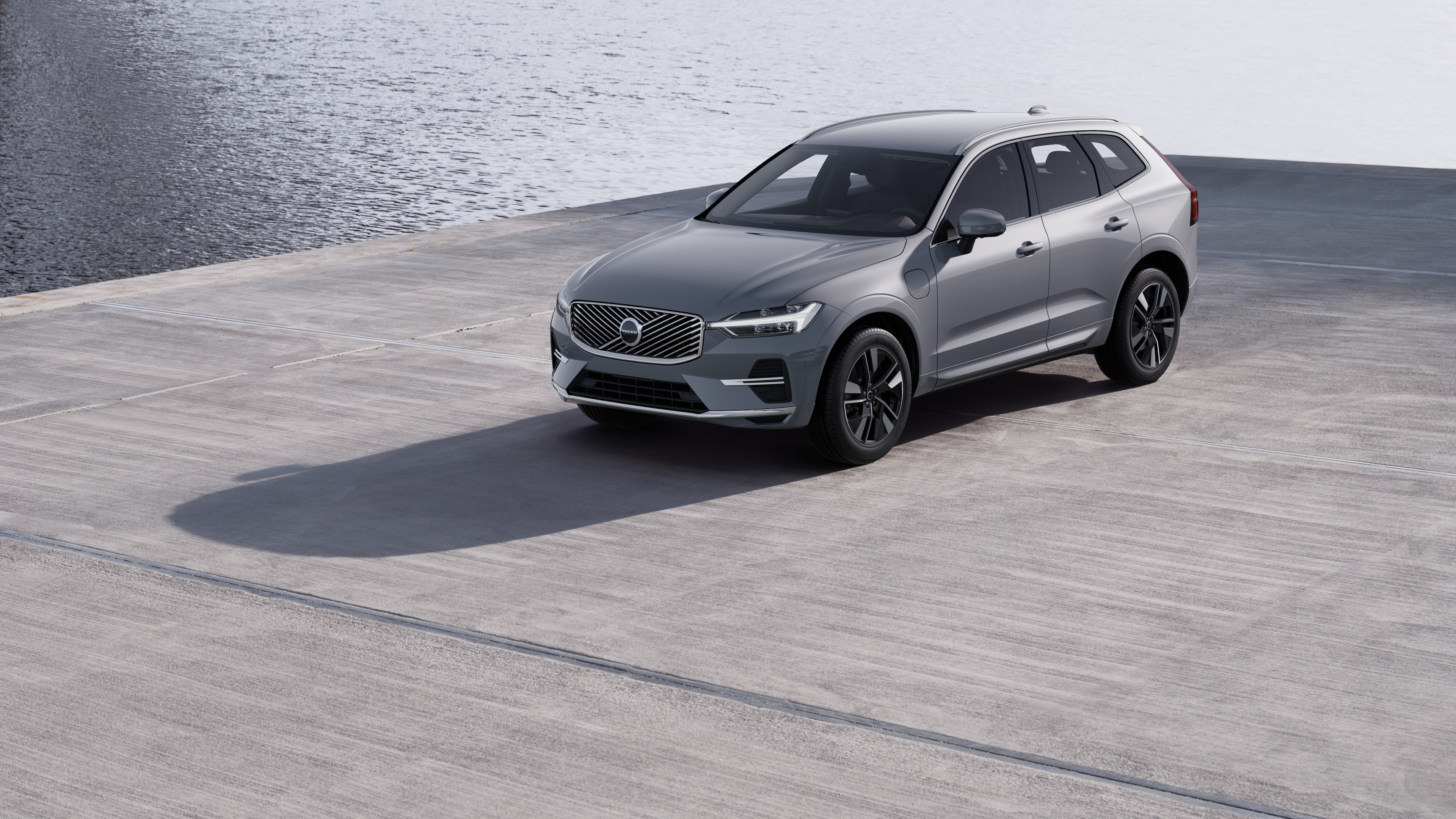 Exteriorul mașinii Volvo într-o vedere pe trei sferturi pe un fundal de zid industrial din beton.