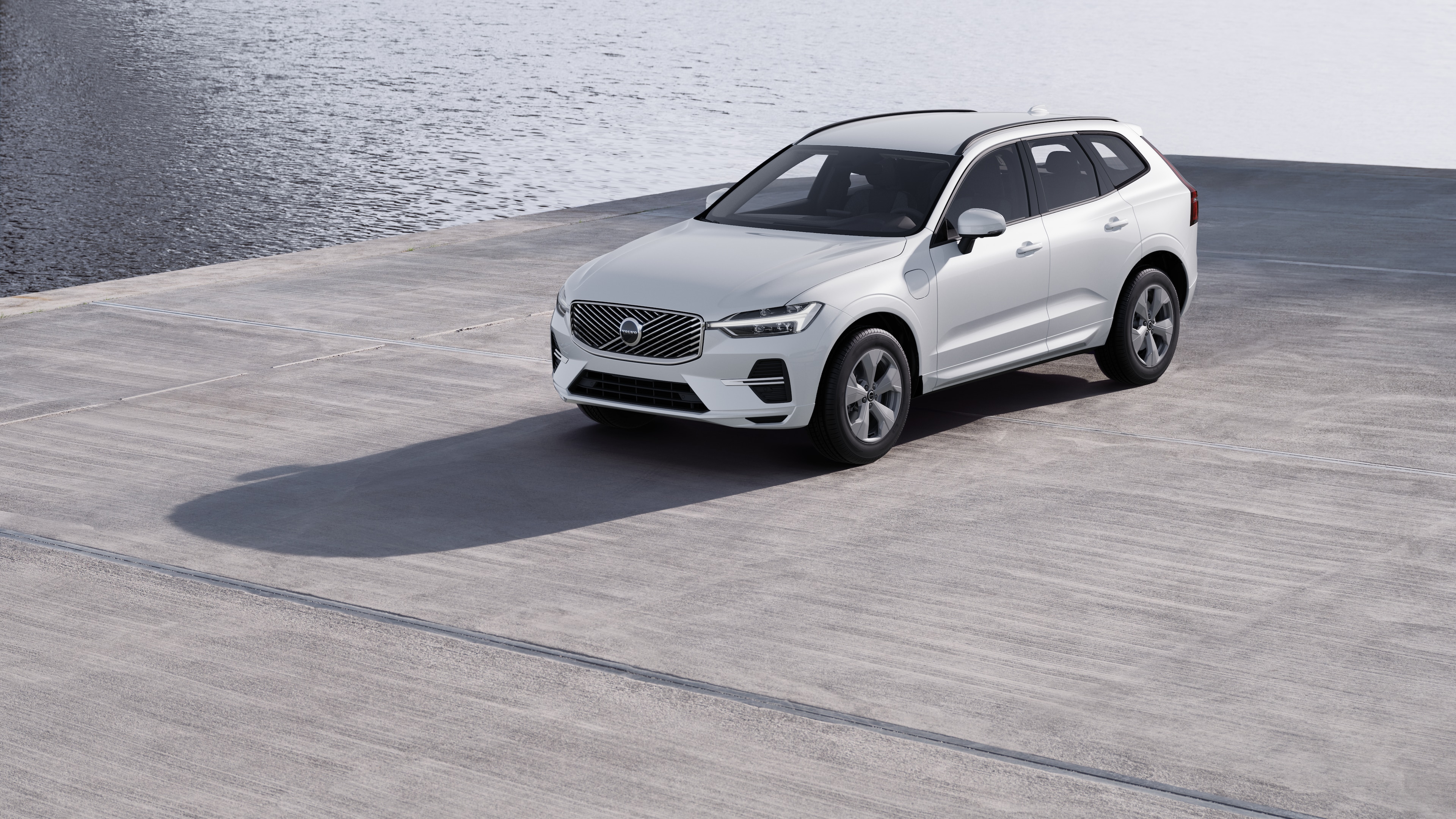 Extérieur d’une Volvo vue de trois quarts sur un fond de mur industriel en béton.