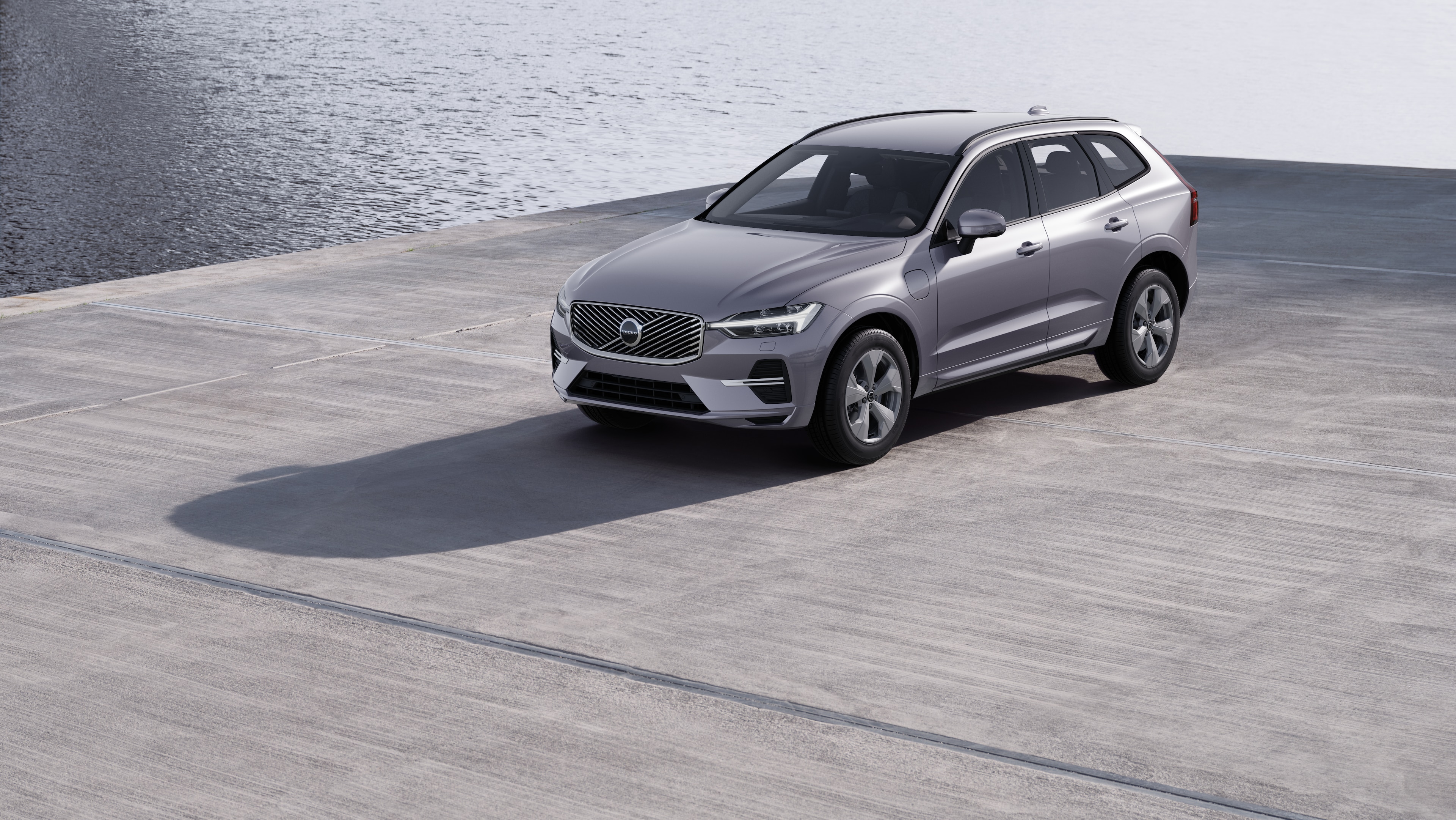 Volvobilens exteriör i trekvartsvy mot en industriell betongväggsbakgrund.