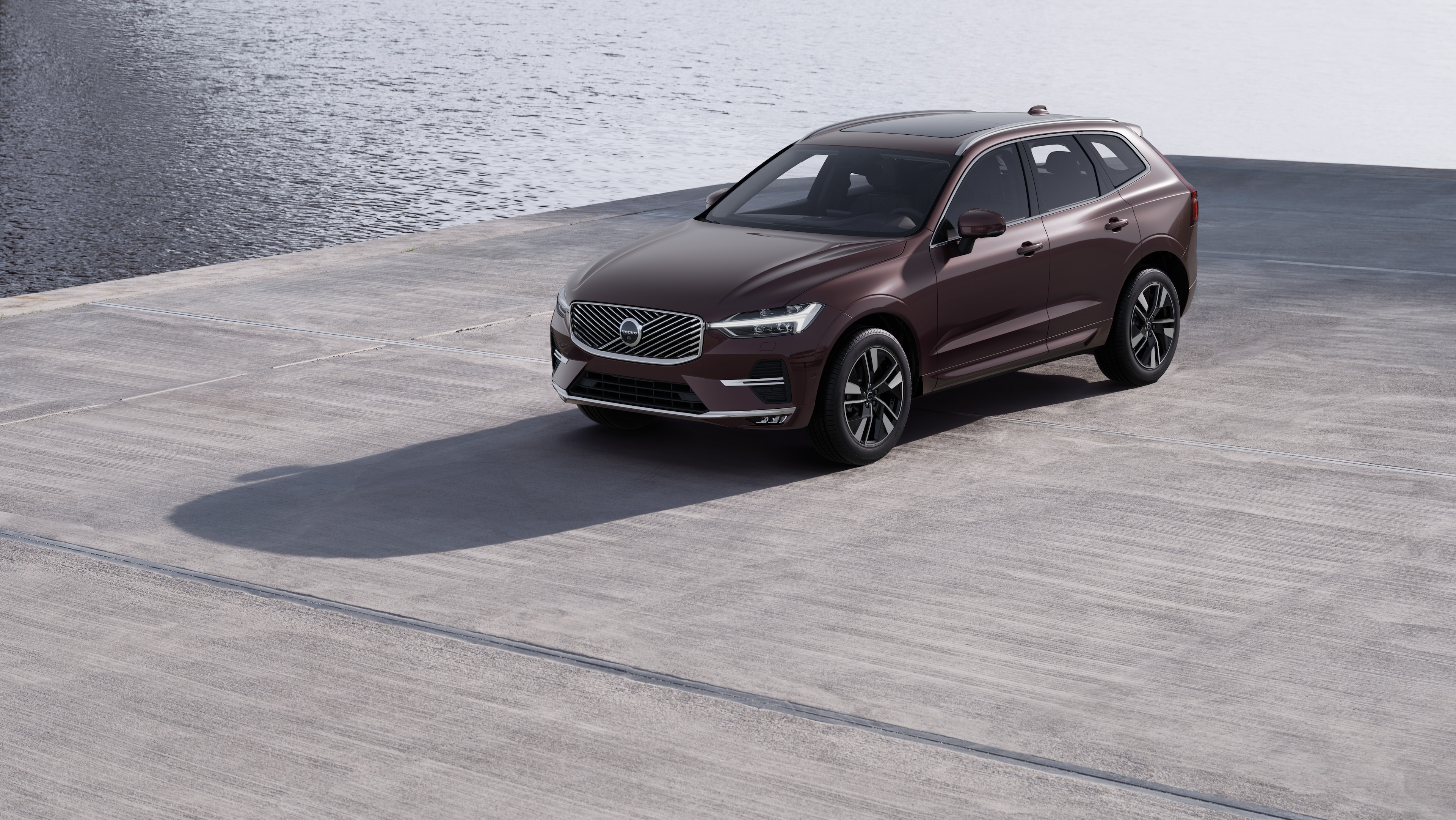 Endüstriyel beton duvar arka planında dörtte üç görünümde Volvo otomobilin dış görünümü.