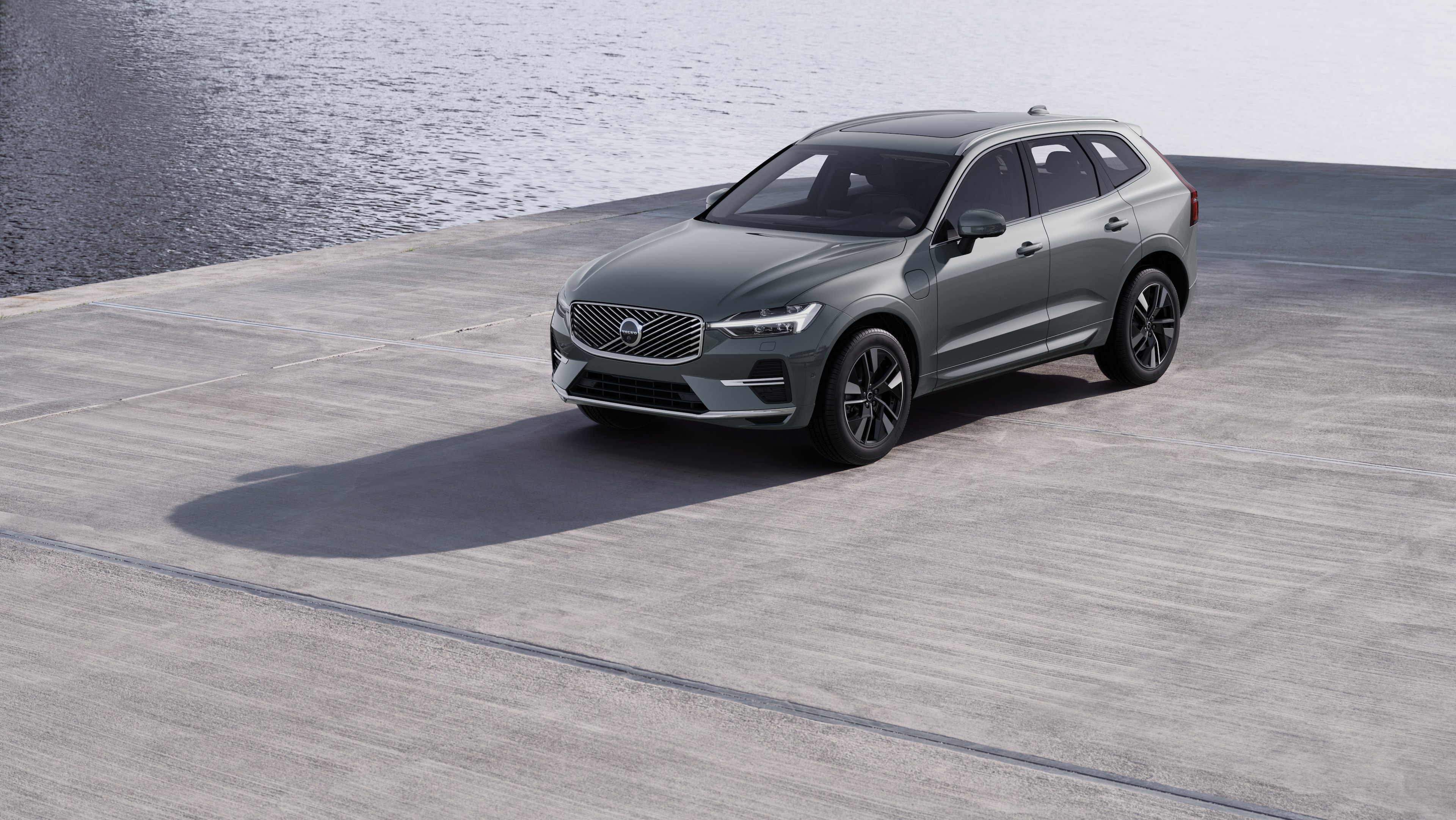 Endüstriyel beton duvar arka planında dörtte üç görünümde Volvo otomobilin dış görünümü.