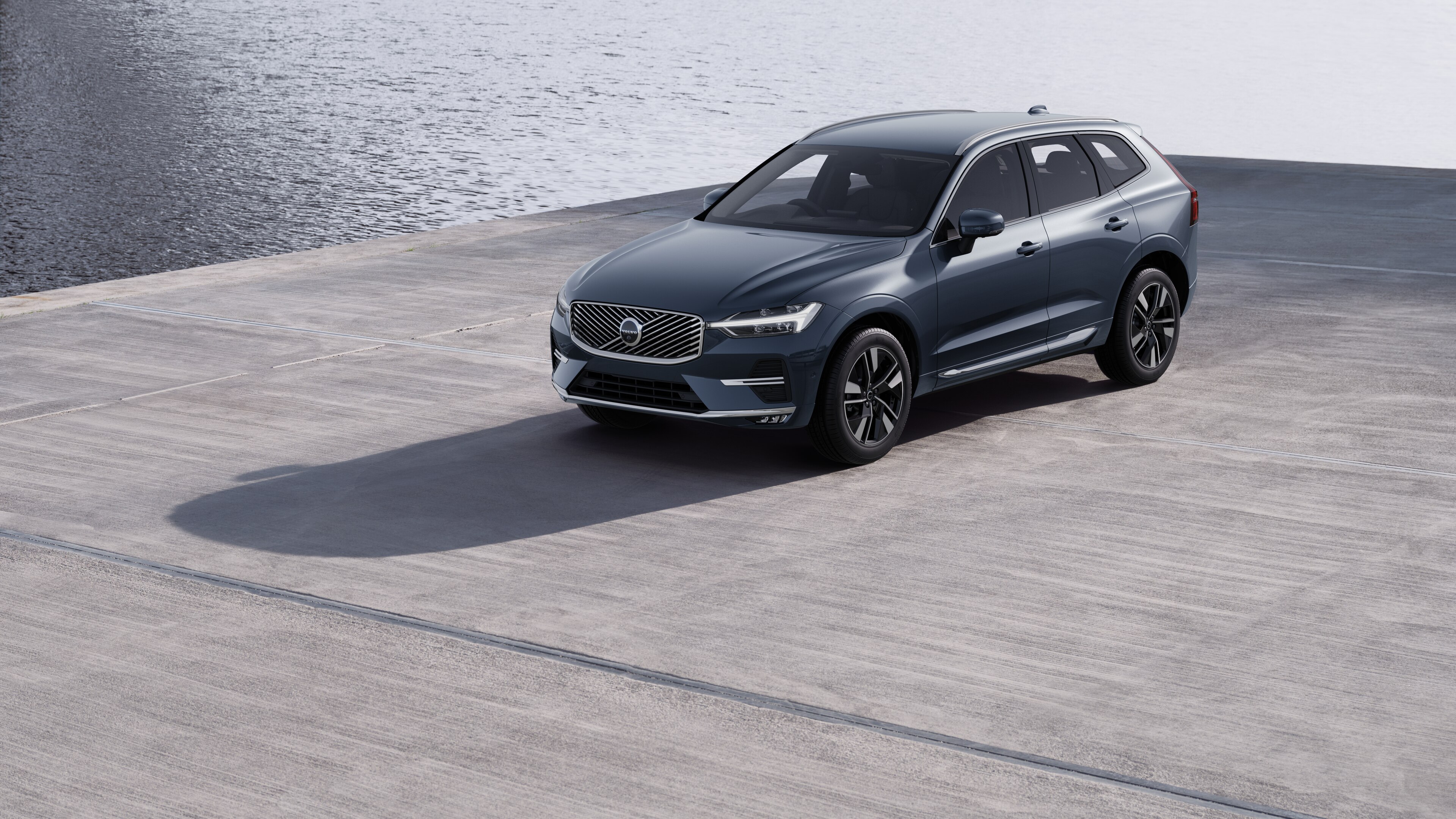 Volvo car exterior in three-quarter view against an industrial concrete wall background.