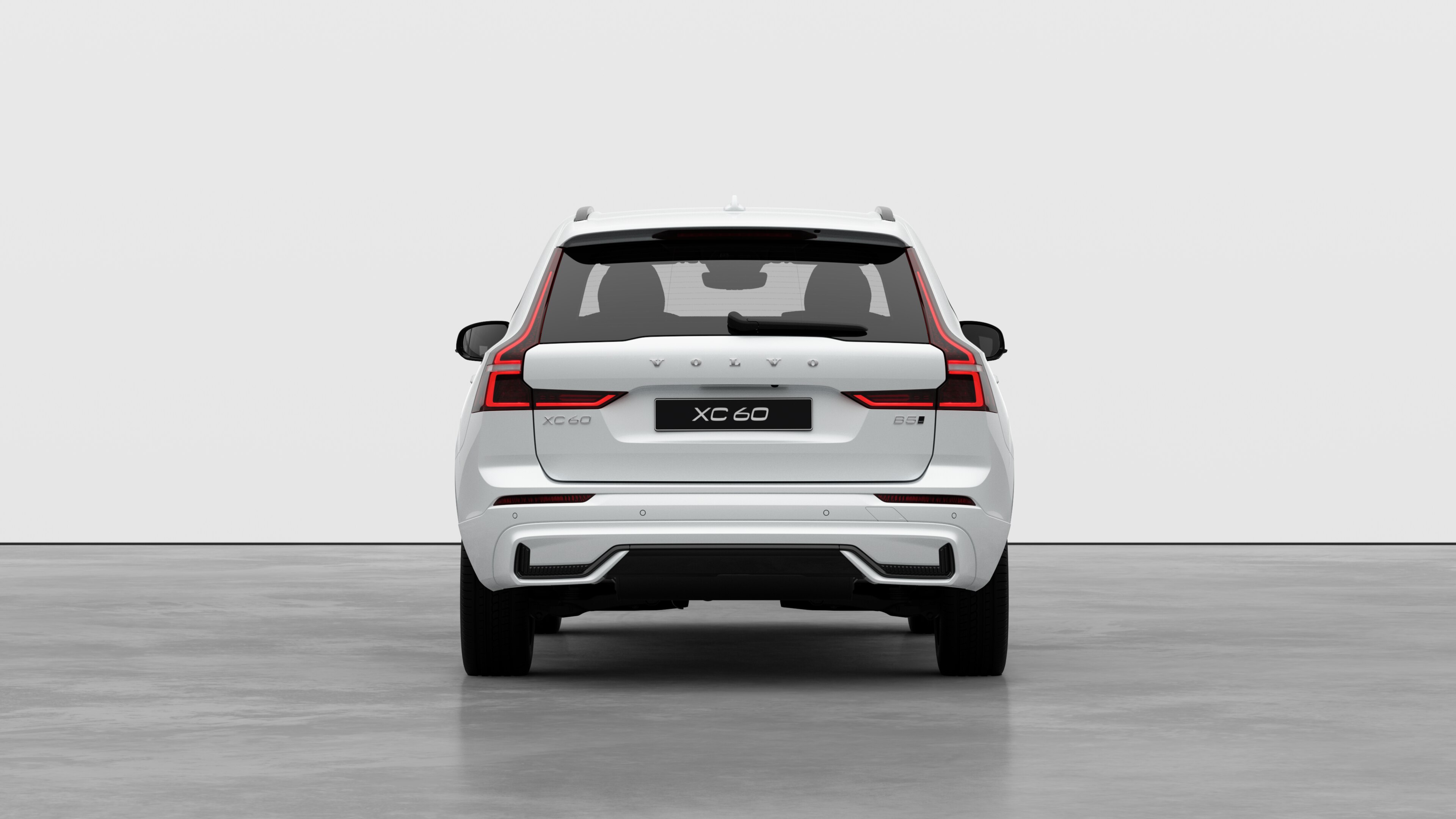 Vue arrière d’une voiture Volvo sur un fond de studio uni.